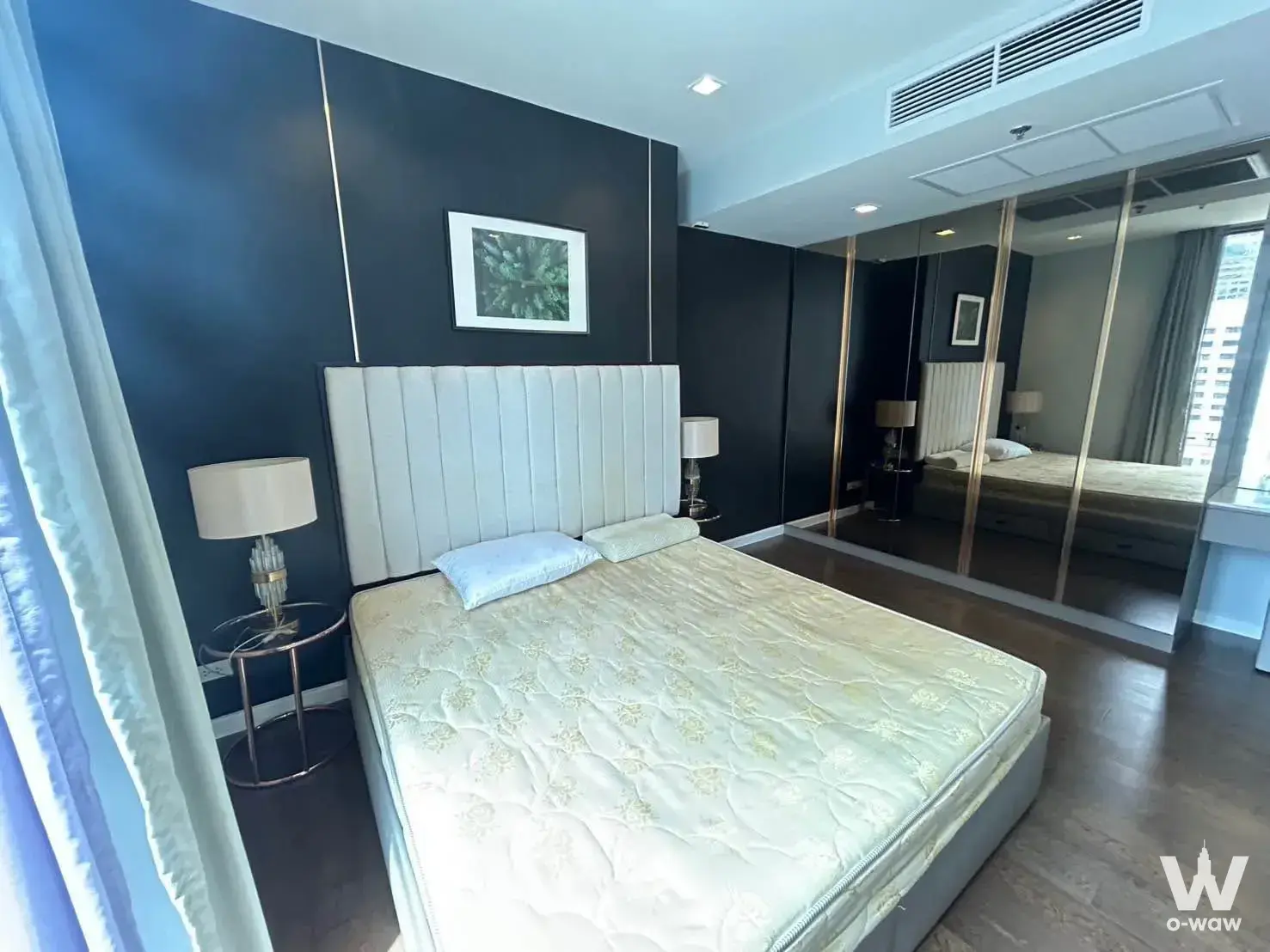 King bed against charcoal wall with gold accents in a 2-bed Nara 9 by Eastern Star condo