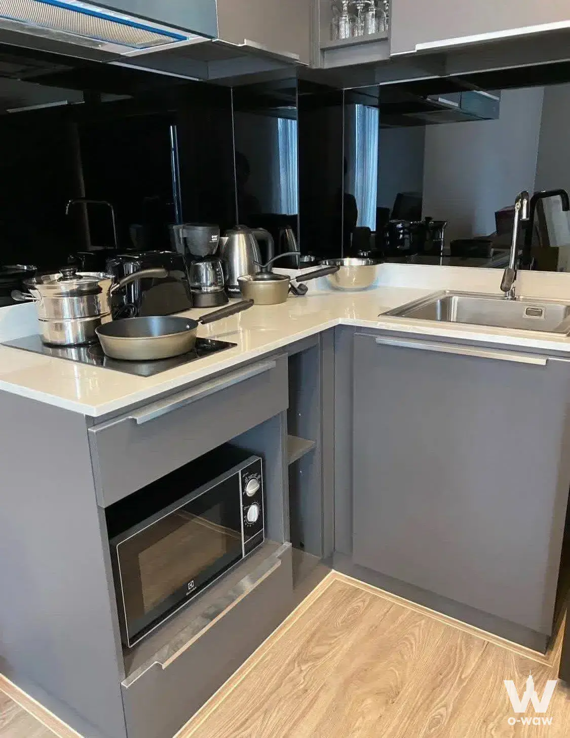 Compact kitchen in a 1-bed condo at The TEAK Sukhumvit 39 with matte grey cabinets and white quartz countertops