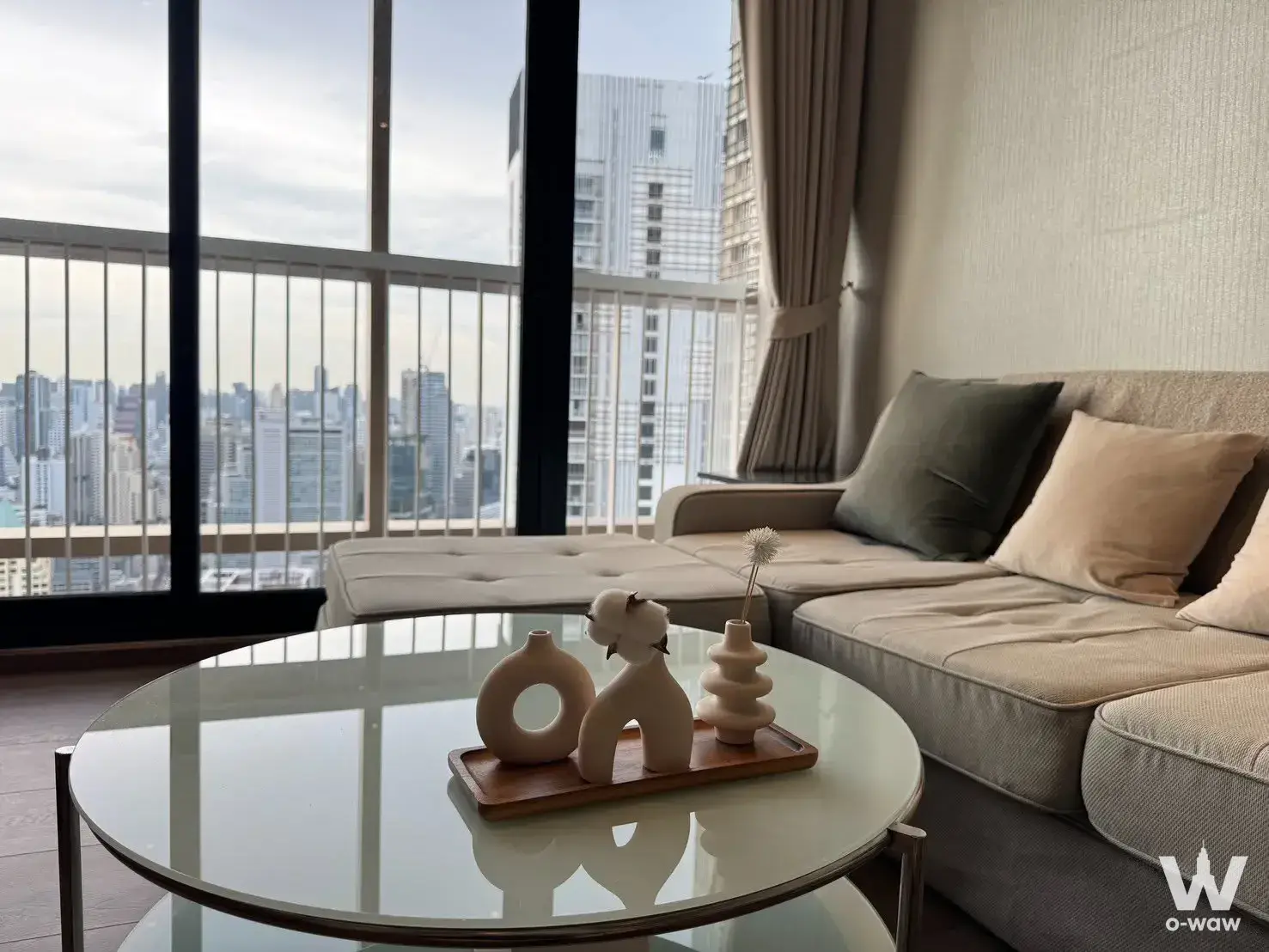 High-floor living room in Park Origin Phrom Phong with an L-shaped sofa and city skyline view
