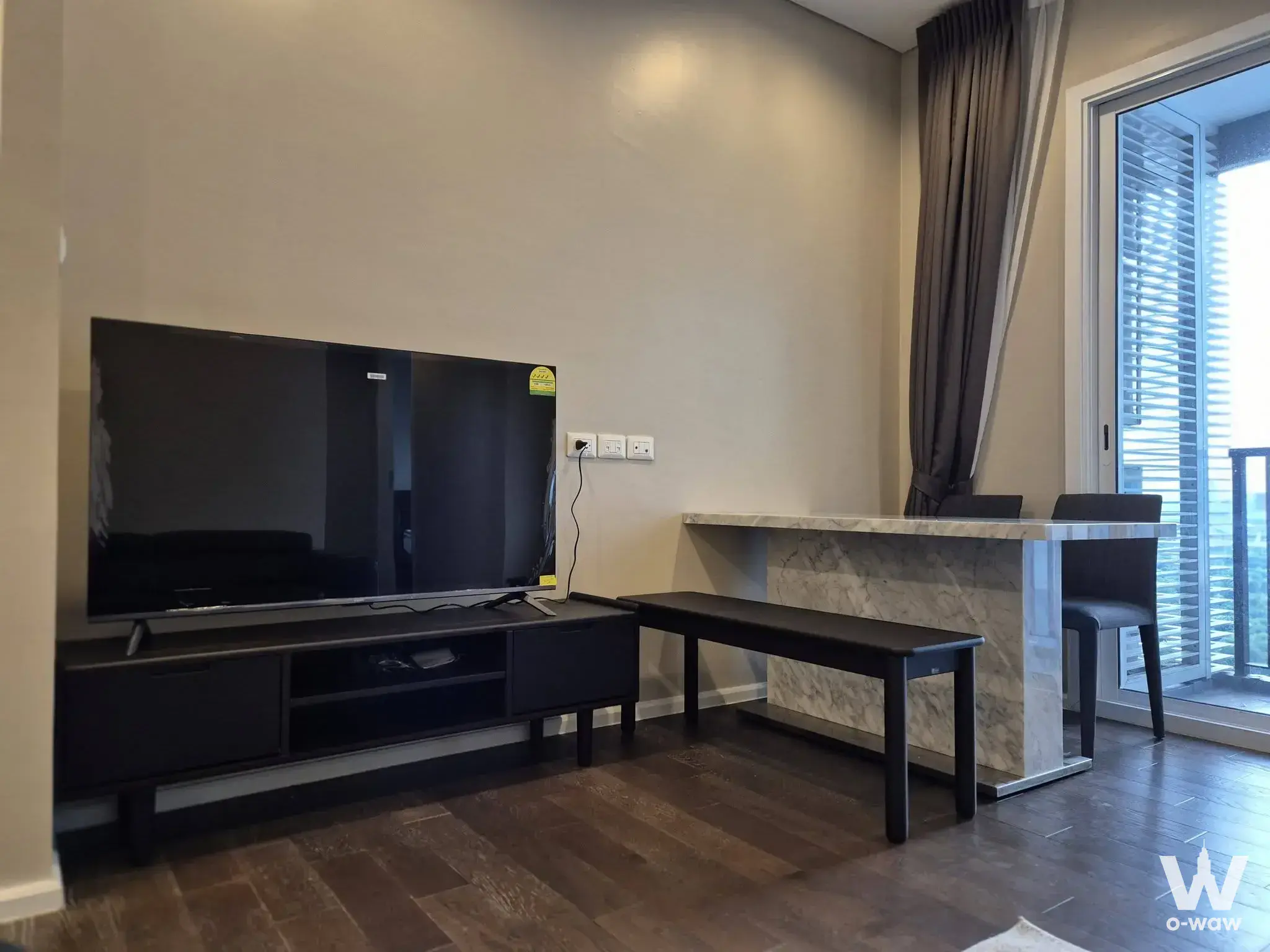 Living room with marble dining counter and balcony access in a 2-bed condo for rent at The Saint Residences