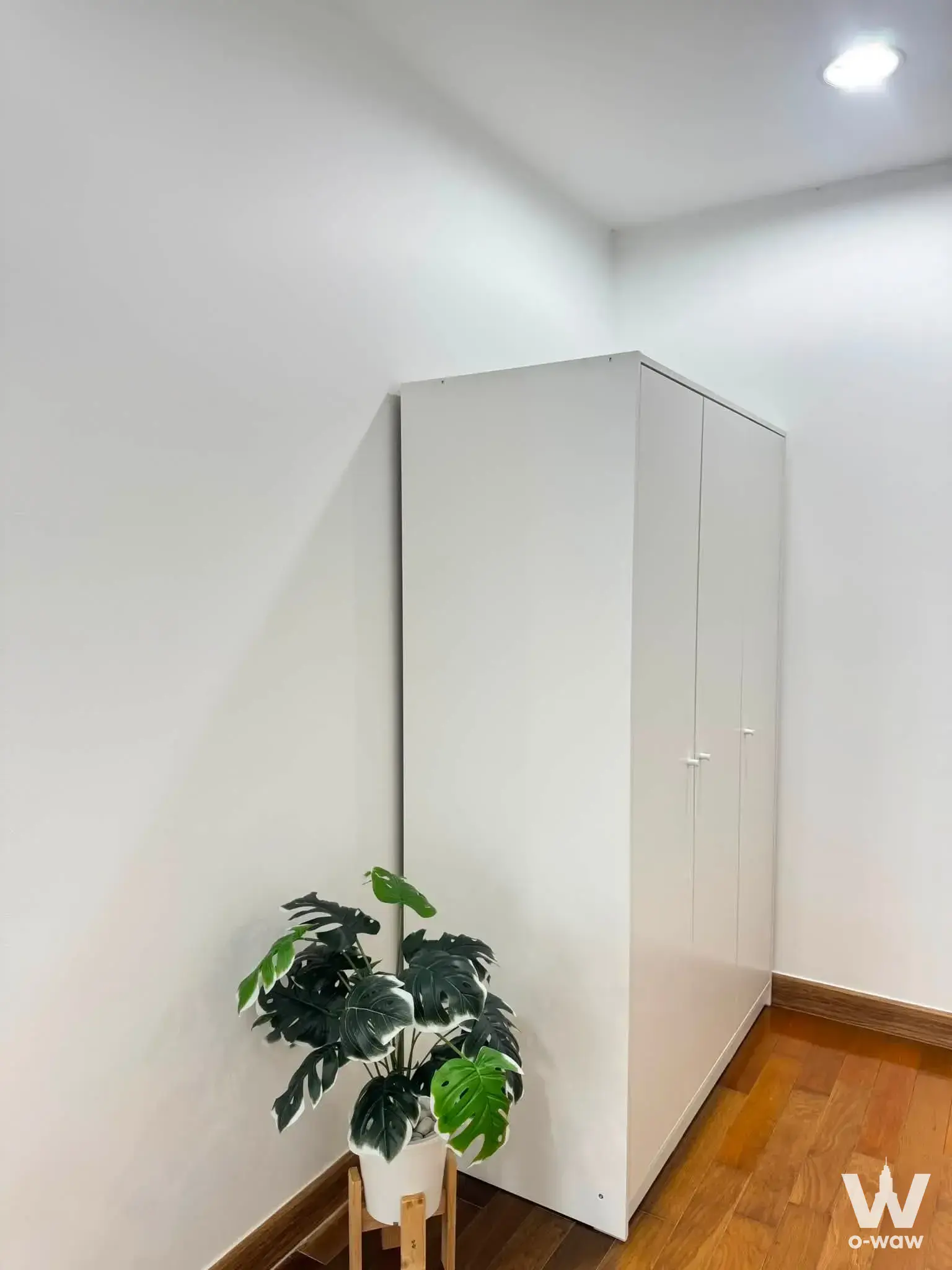 Bedroom corner in THE LINE Phahonyothin Park sale unit showing a floor-to-ceiling wardrobe and Monstera plant