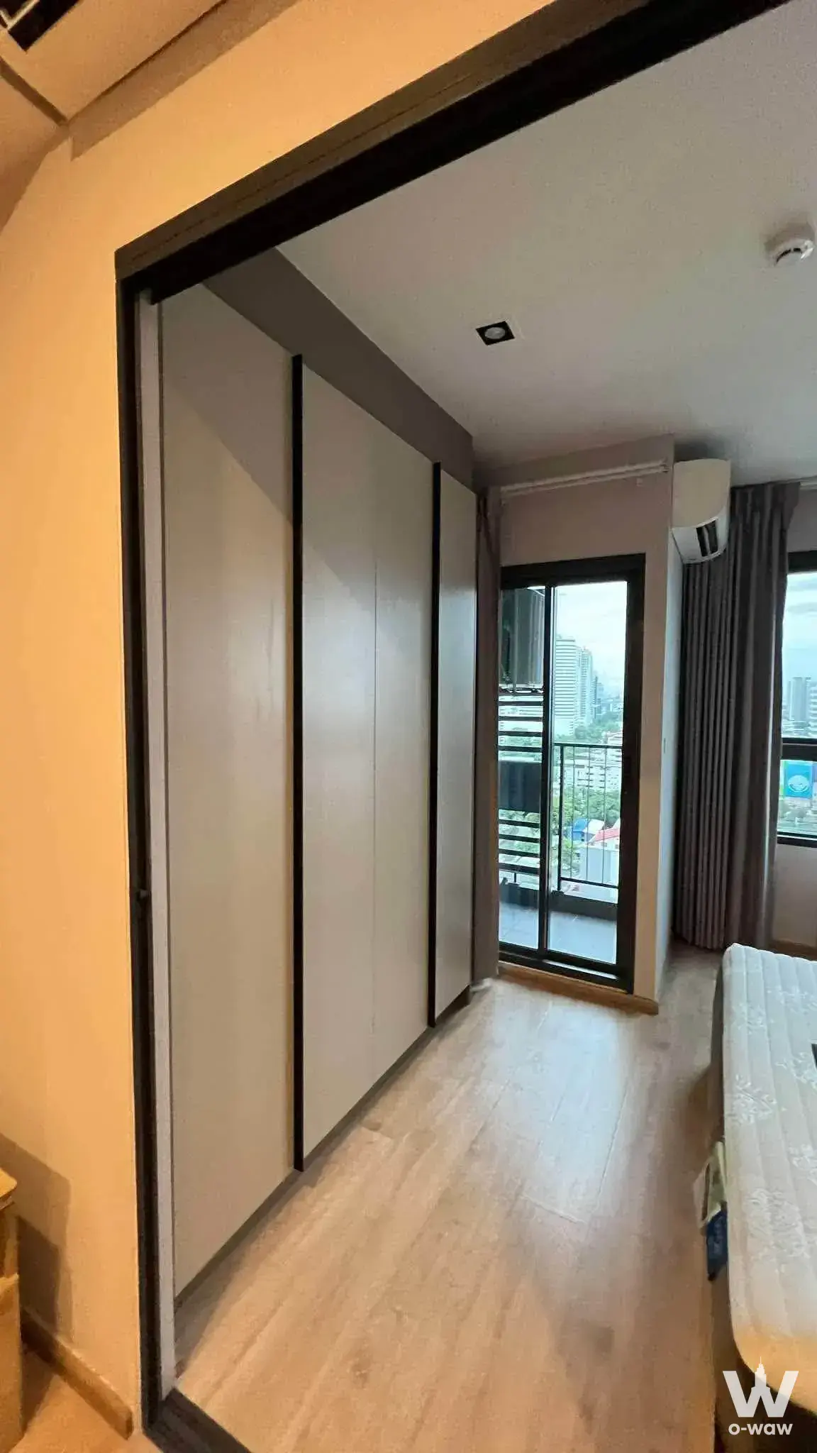 Bedroom in a 1-bed condo for rent in IDEO Rama 9 - Asoke has a built-in wardrobe and balcony with city view
