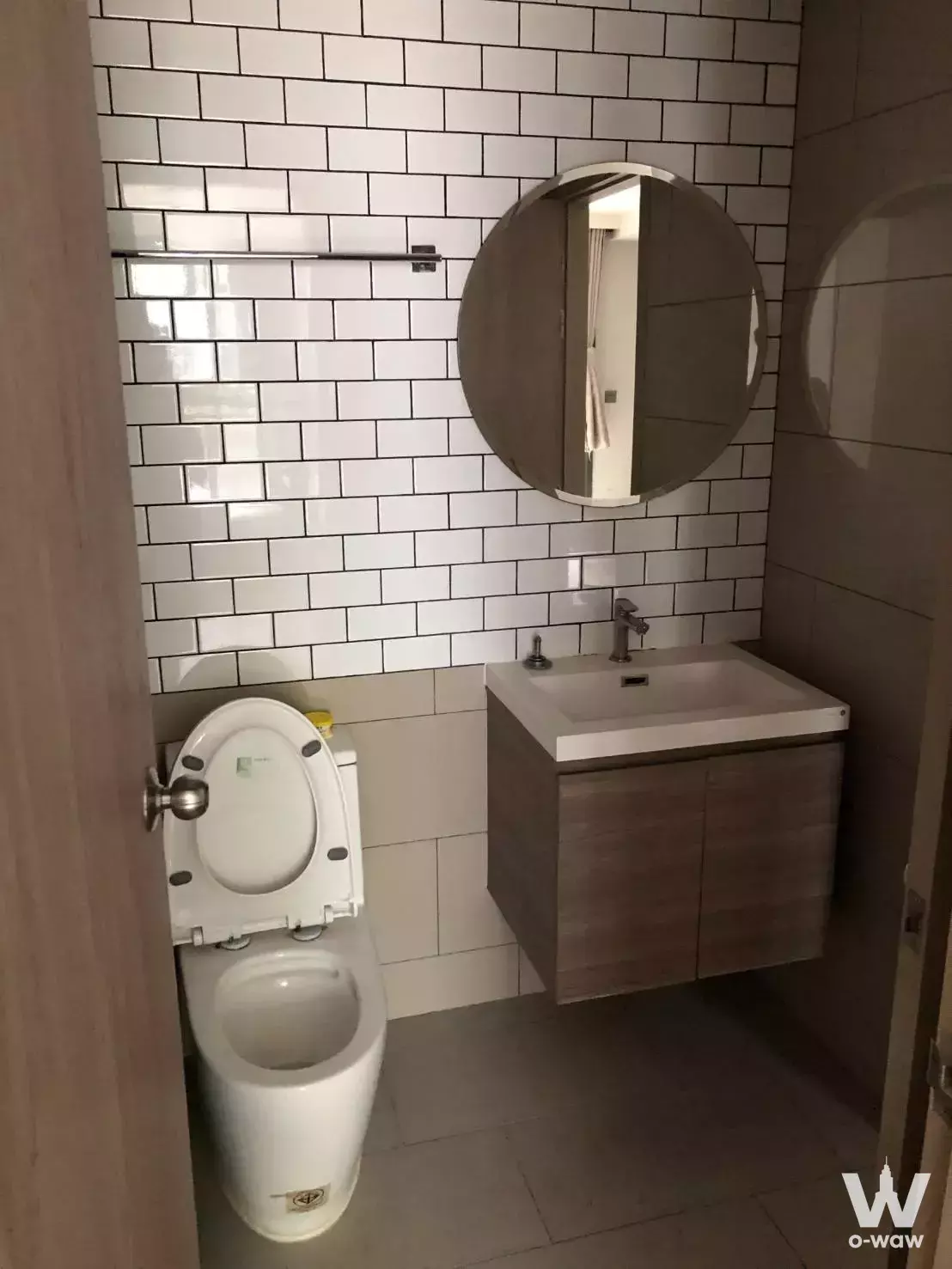Compact bathroom in Maestro 19 Ratchada19 with white subway tiles and a floating wood-grain vanity
