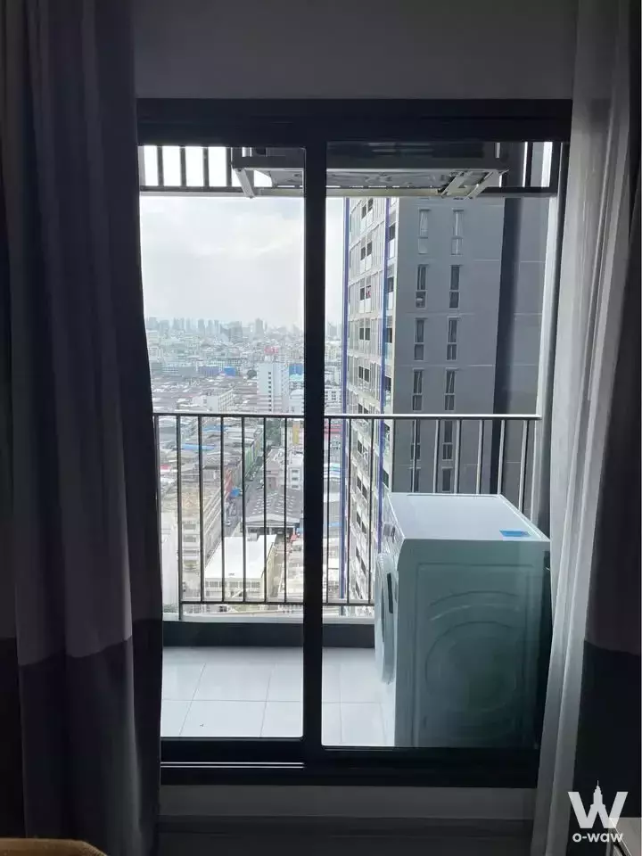Balcony with washing machine and city view in a 1-bed condo for rent at Life Asoke, Rama 9