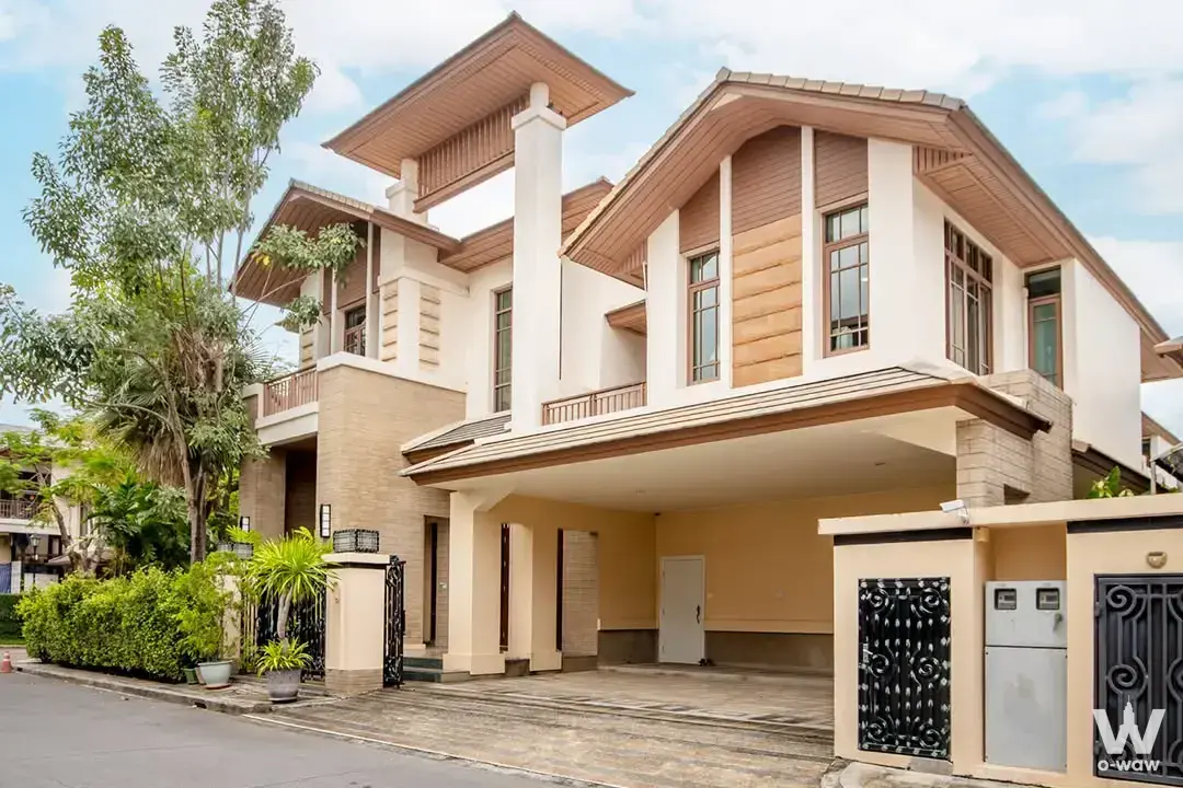 Two-story cream house for sale at Baan Sansiri with wood accents and covered driveway
