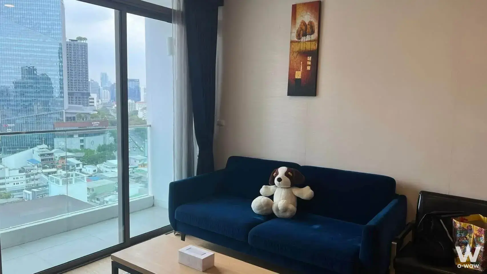 Siamese Surawong 3-bed condo living room with navy sofa and balcony city view