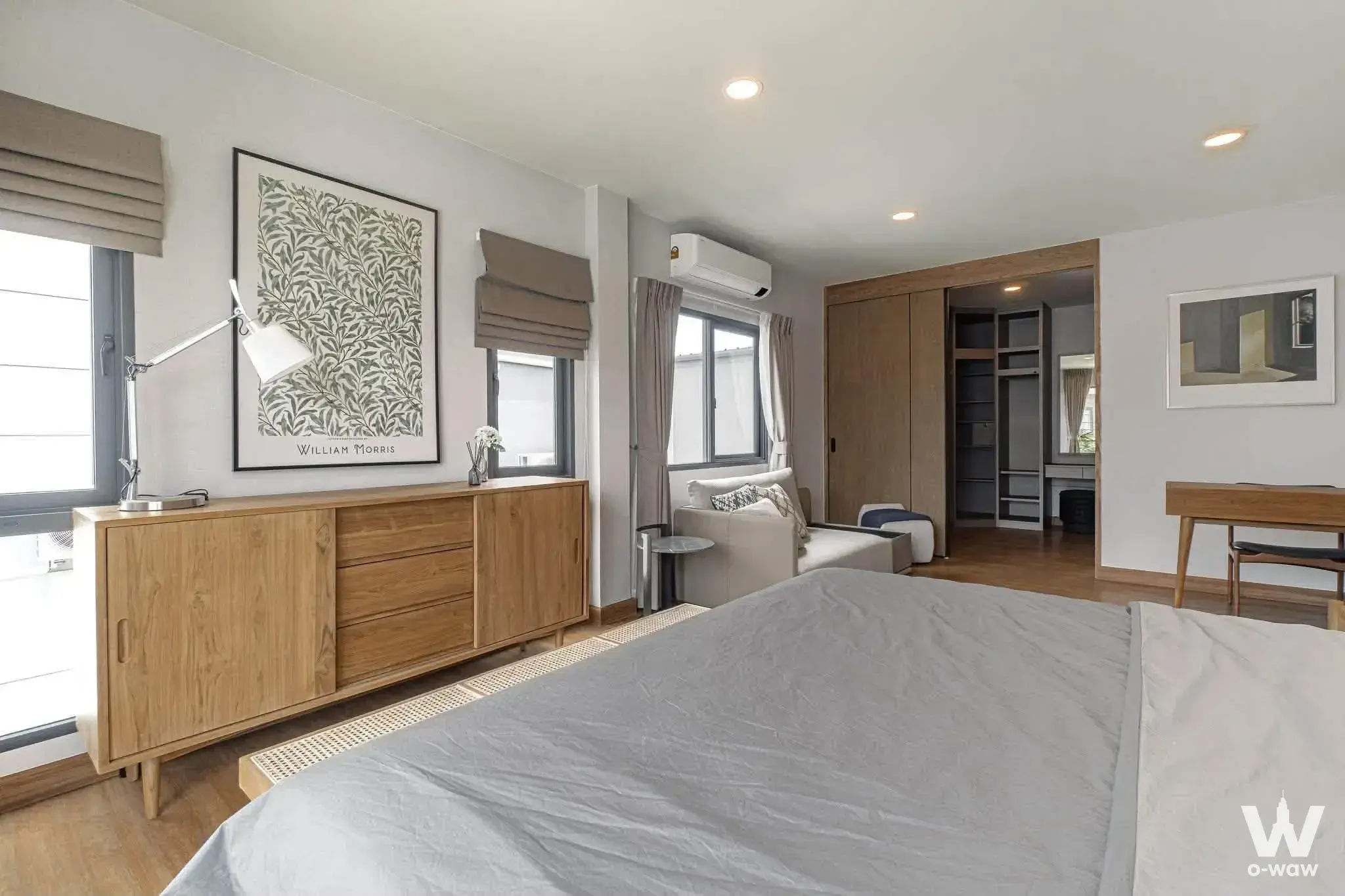 Scandinavian master bedroom in a Silom condo featuring oak furniture and a walk-in closet