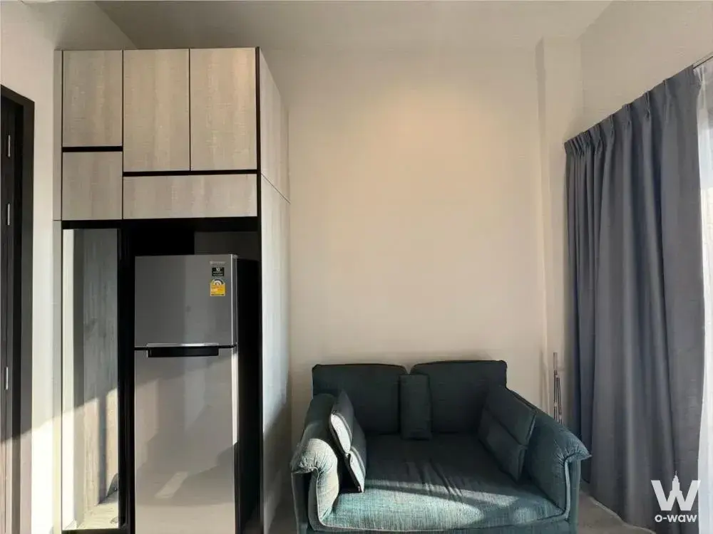 1-bed condo for rent in THE LINE Sukhumvit 71 featuring a teal sofa and light wood cabinetry
