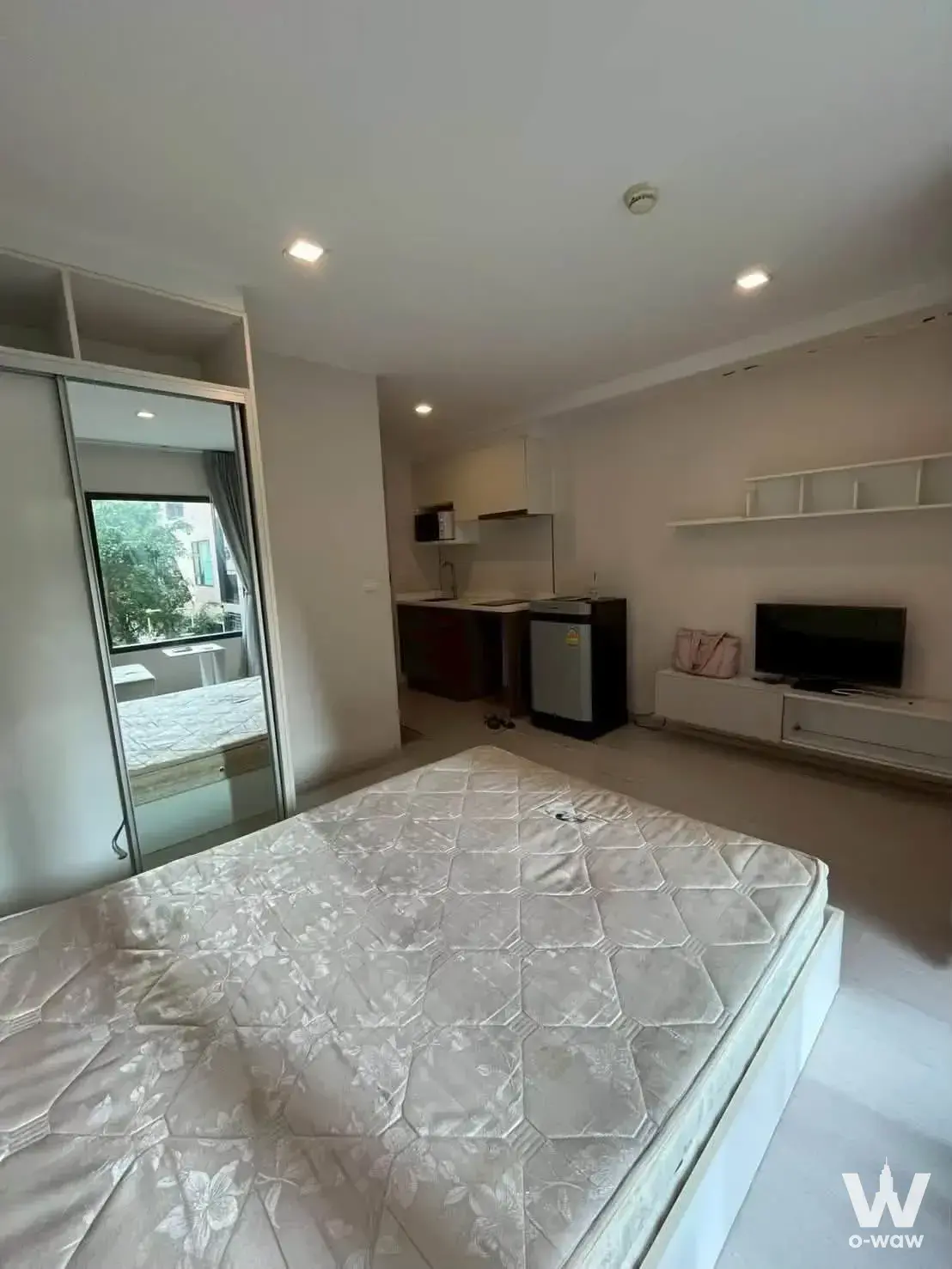 Open-plan studio in Condolette Pixel Sathorn with bare queen mattress and compact kitchenette