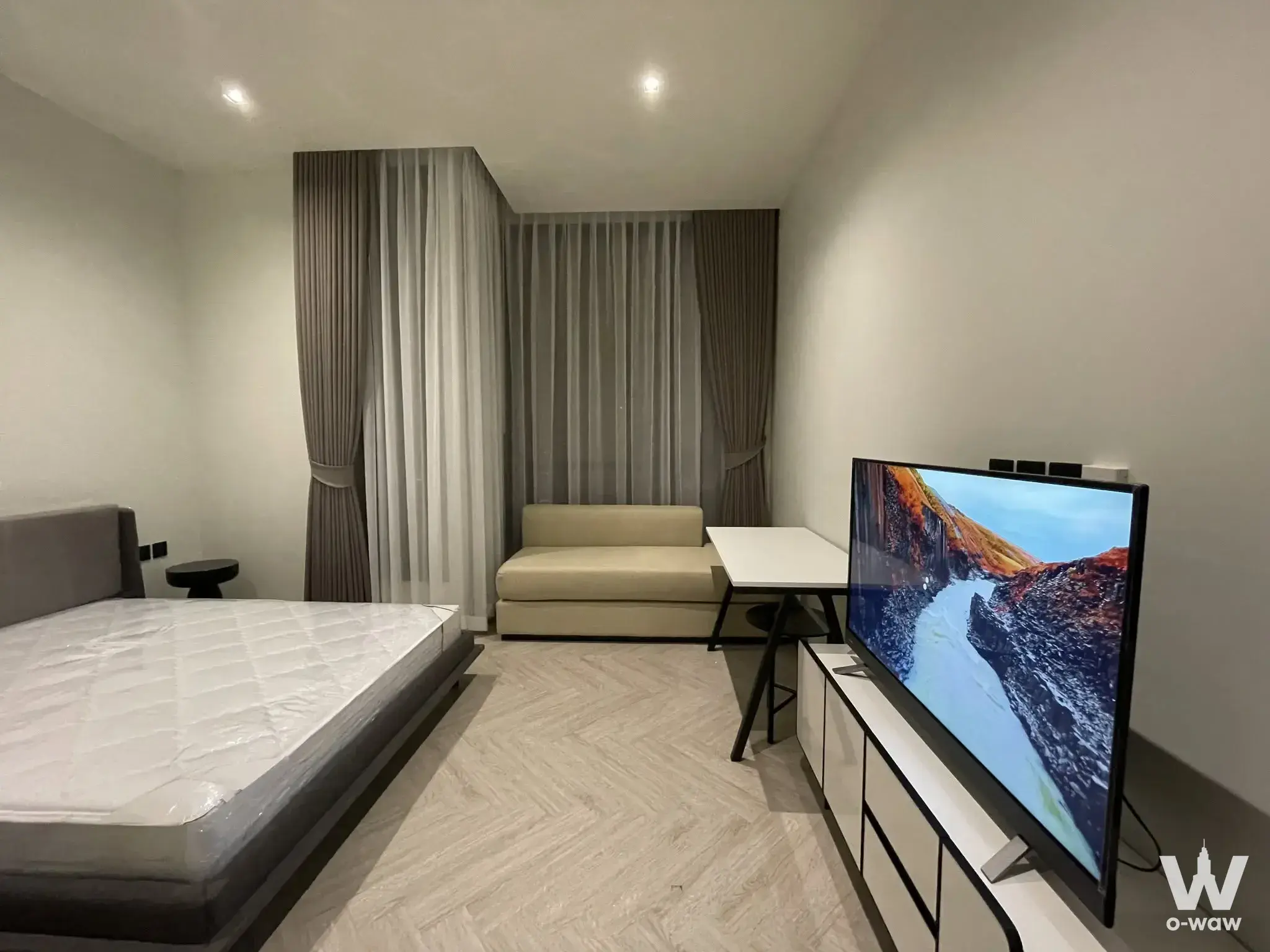 Queen bed and window bay sofa in this 1-bed condo for rent at Chapter Charoennakhon Riverside