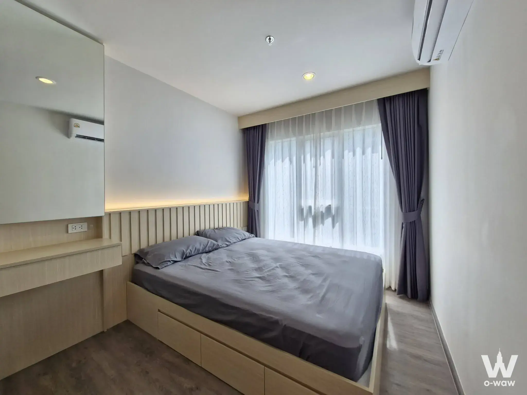 Bright 1-bed condo bedroom in Regent Home Bangna with LED headboard lighting and full-height window