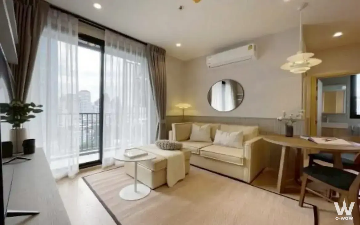 Cream leather sofa and dining set in a furnished 1-bed condo for rent at MARU Ekkamai 2