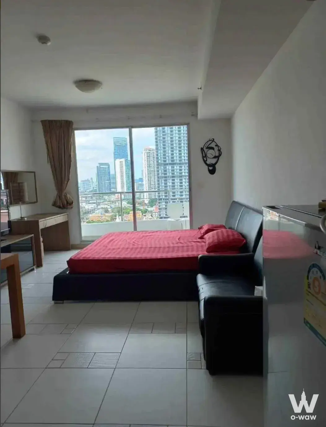 Open-plan studio in Supalai River Place with queen bed, leather sofa and balcony city view