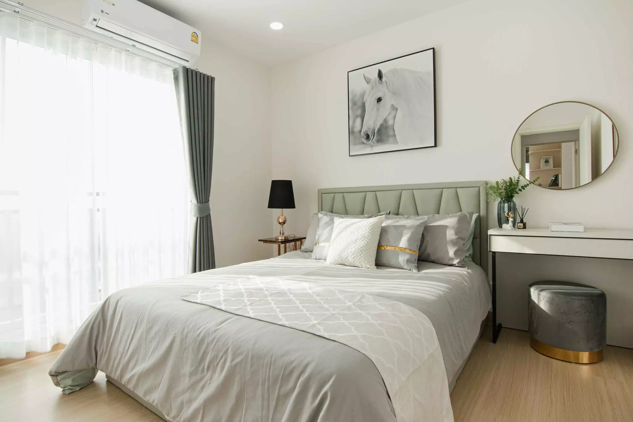 Queen bed with gold-trimmed pillows and horse art in a bright bedroom of this Supalai Veranda Ratchawipha-Pracha Chuen condo