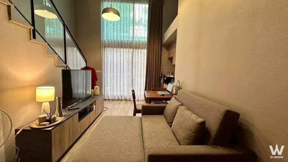 Modern furnished loft studio in Blossom Condo Sathon-Charoen Rat with mezzanine, wooden stairs, and dining area