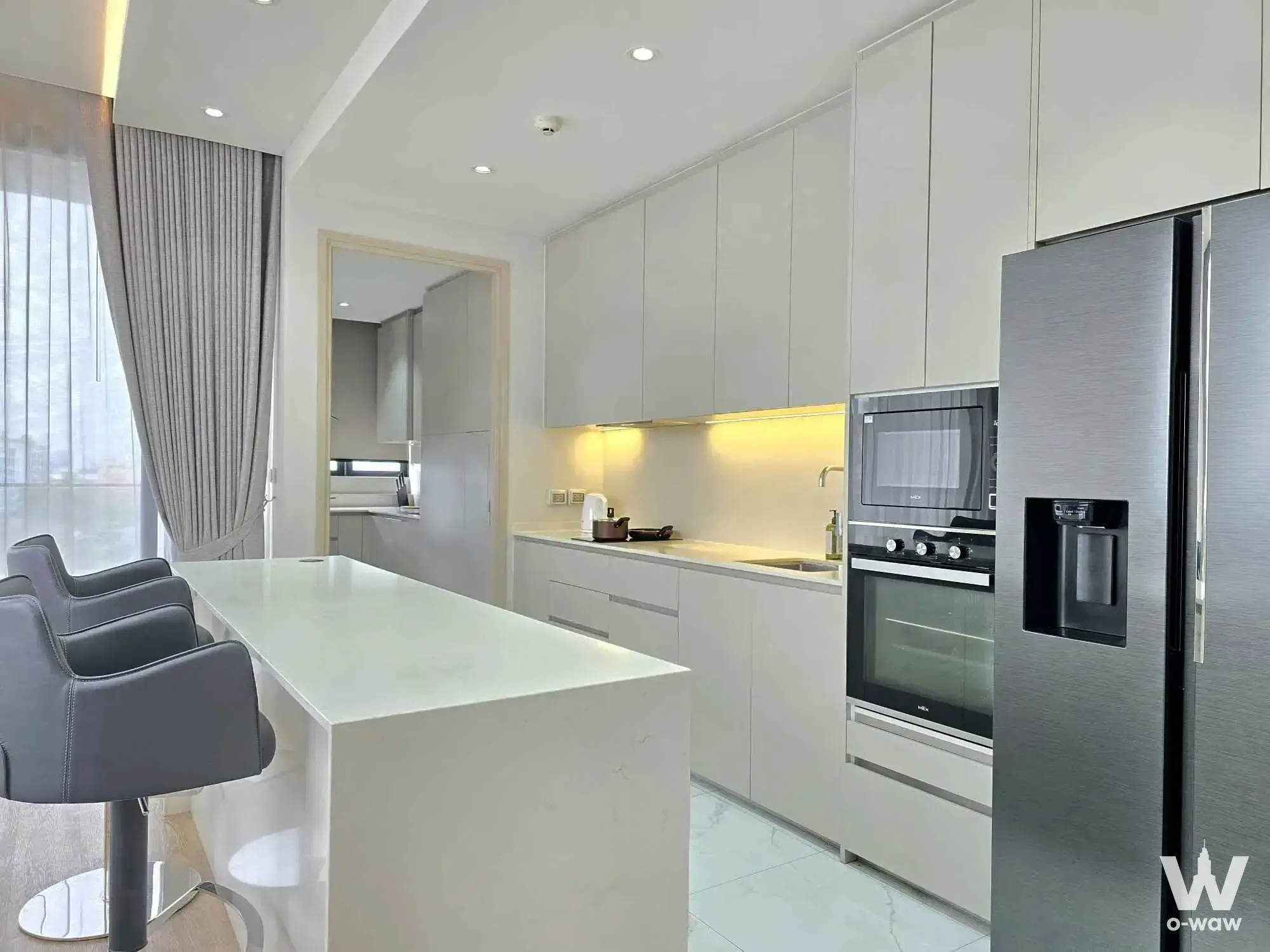 Modern kitchen with a large quartz island and floor-to-ceiling cabinetry in this 3-bed Bearing Residence condo for rent
