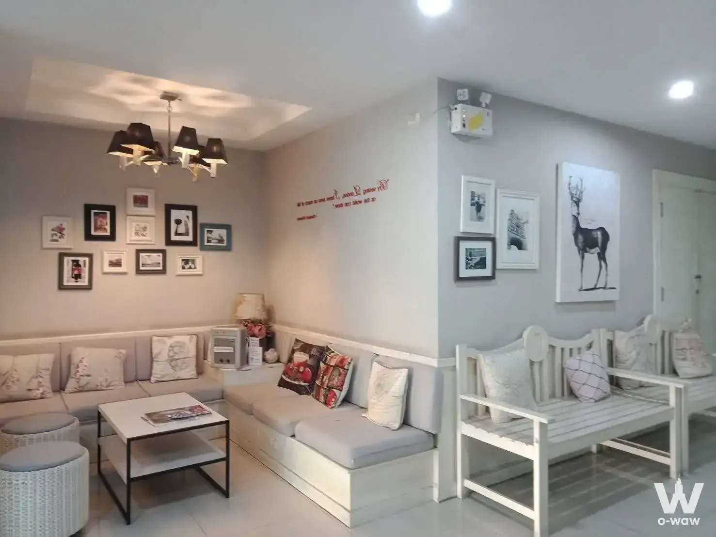 Bright living room in a Sense of London 1-bed condo with L-shaped bench seating and wicker poufs