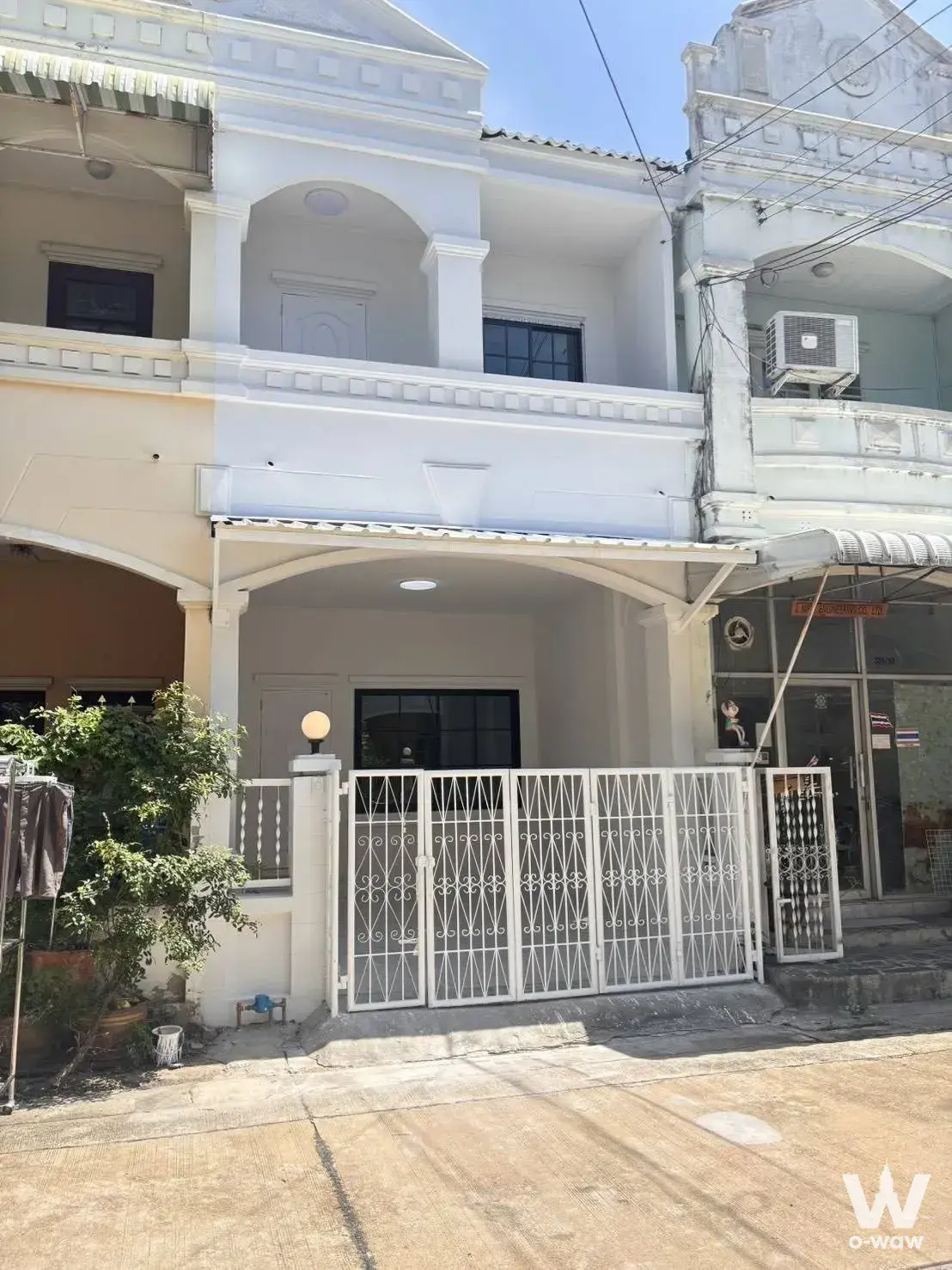 White colonial-style 2-bed townhouse for sale in Laphawan 7 with arched balcony and metal gate