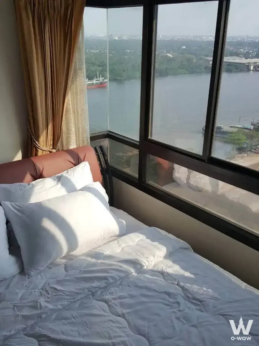 Bedroom in Home Lumpini Place Narathiwas featuring a corner window bay overlooking the river