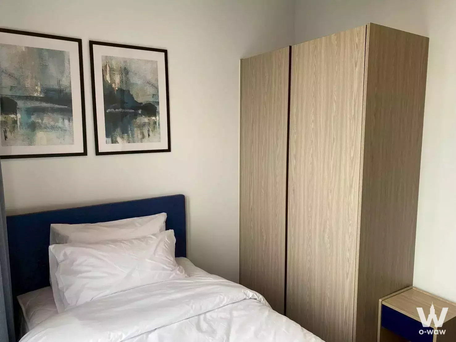 Navy upholstered bed and oak wardrobe in XT Ekkamai 2-bed condo bedroom