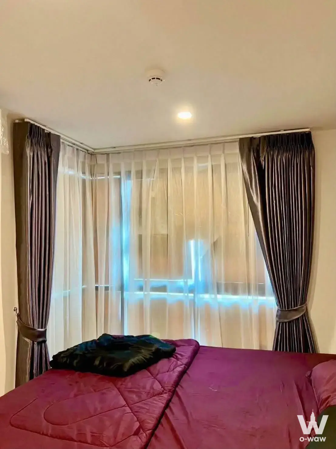 Bedroom in The Excel Hideaway Sukhumvit 50 with magenta comforter and corner window