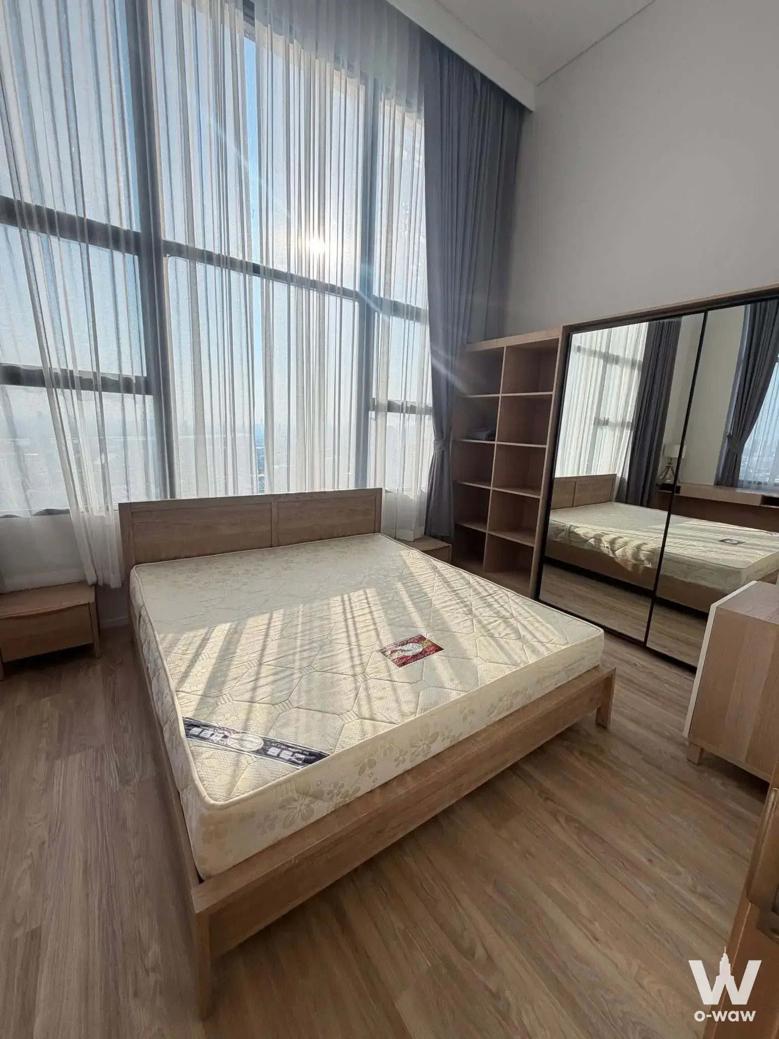 Ramada Plaza Sukhumvit 48 2-bed condo bedroom for rent with oak bed frame and floor-to-ceiling windows