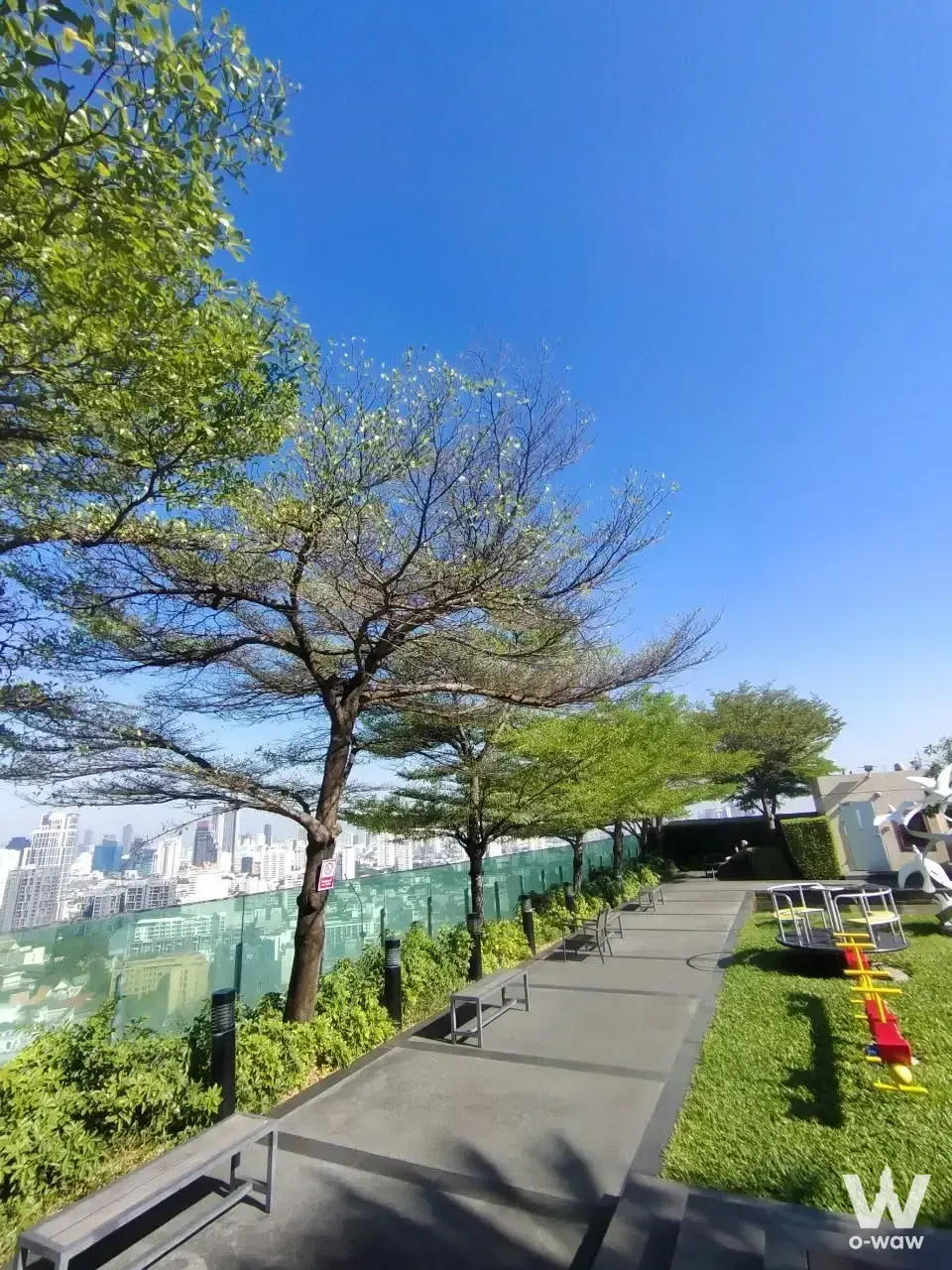 Rooftop garden with paved walkway and city skyline view at this 1-bed condo for rent in Life @ Sukhumvit 65
