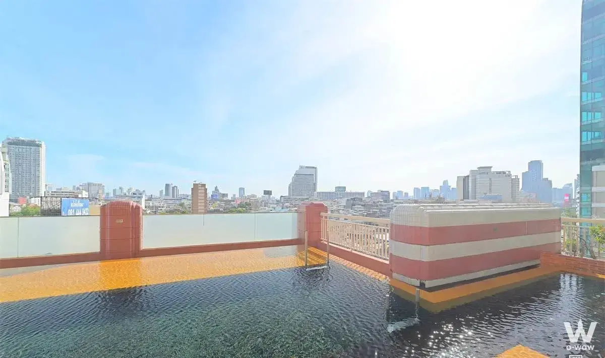 Rooftop pool with orange mosaic tiles overlooking the skyline at Manhattan Chidlom