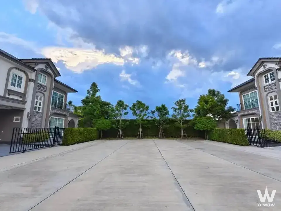 Exterior of a 4-bed house for rent in Grandio Bangna KM.5 showing two-story townhouses and manicured hedges