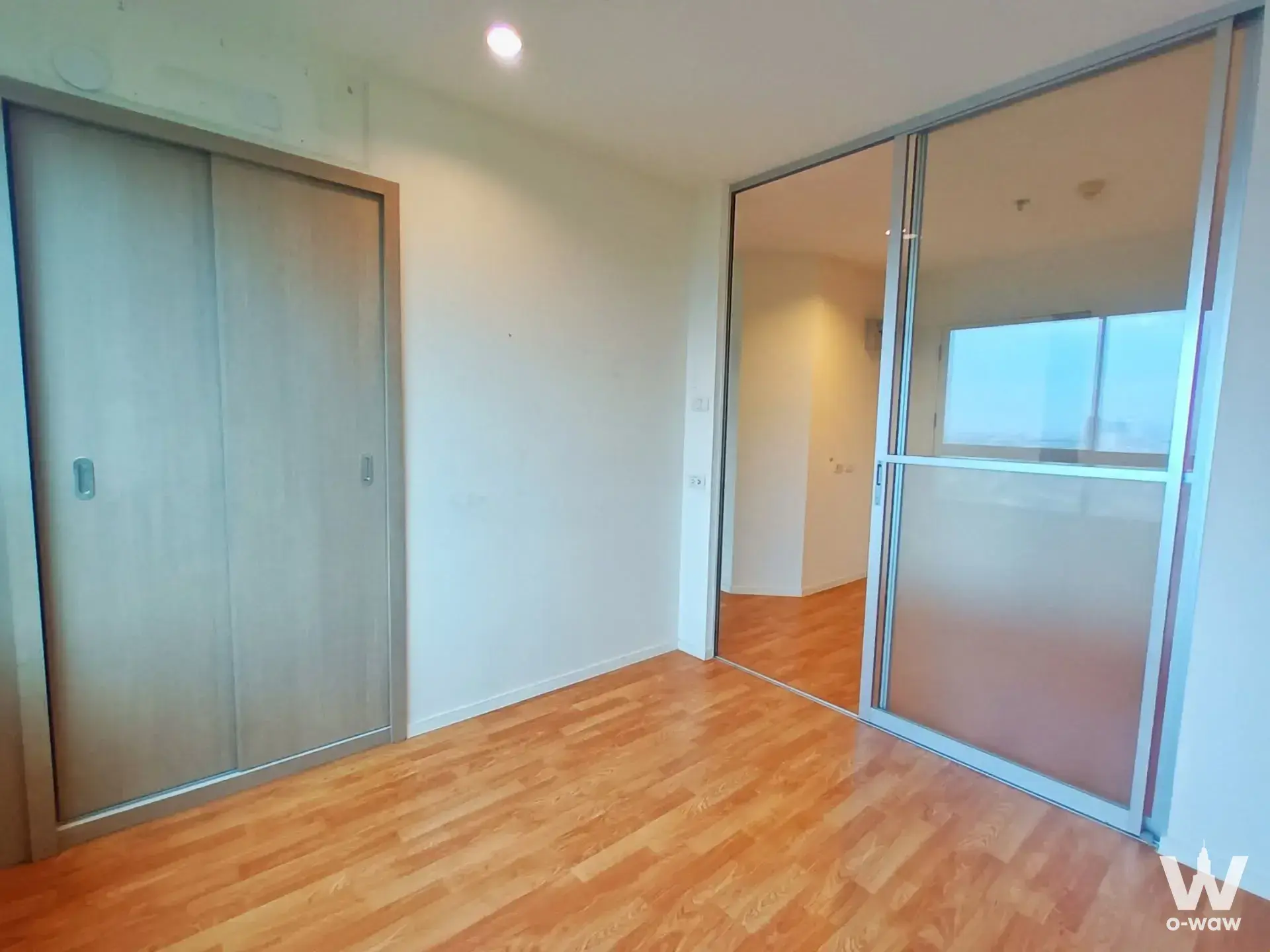 Unfurnished bedroom in Lumpini Park Phetkasem 98 with light oak floors and sliding wardrobe doors