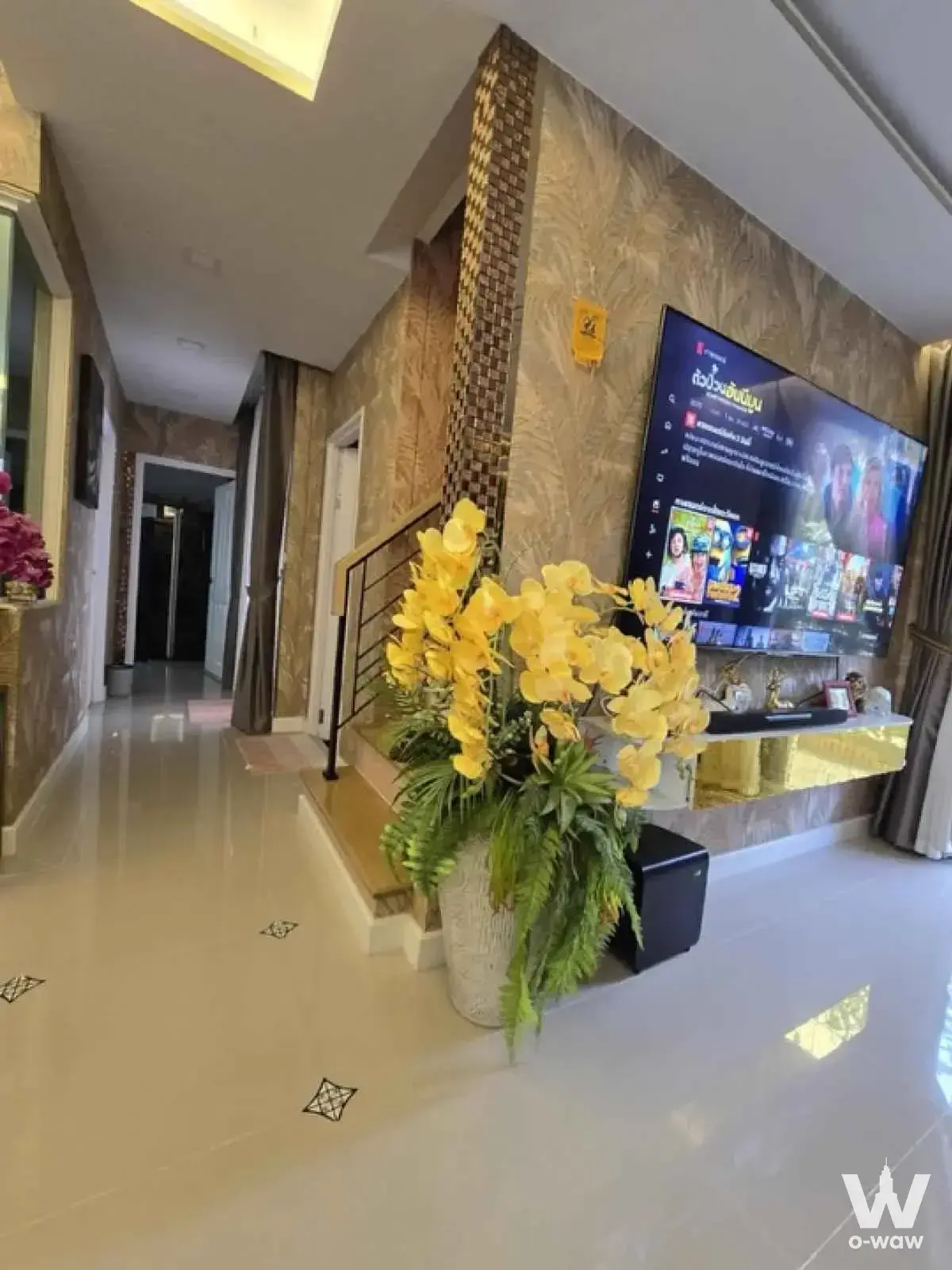 Luxury living room with gold wallpaper and orchids in a 4-bed condo for rent at Prestige Future-Rangsit