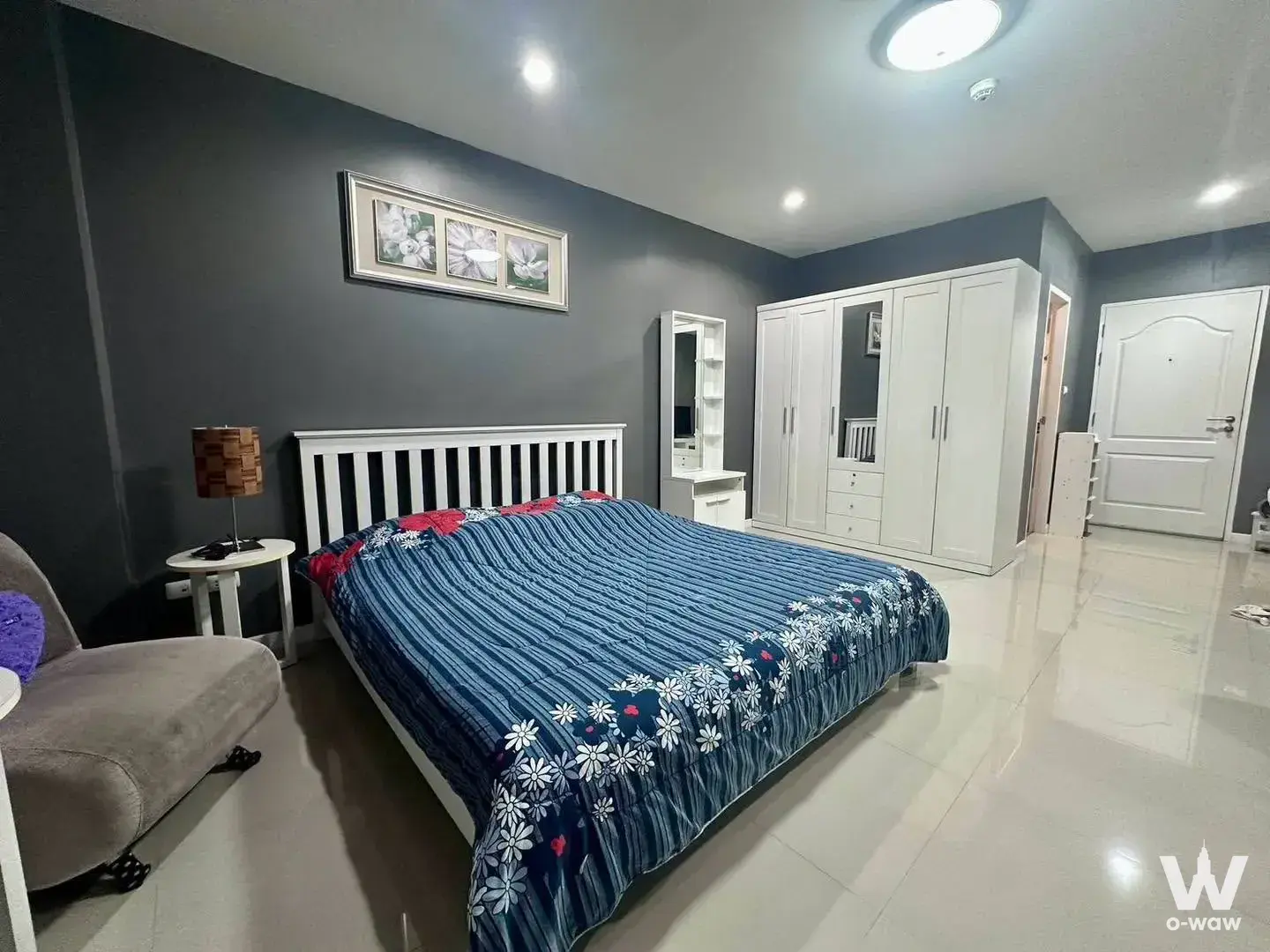 Modern bedroom in Sense of London Condo featuring dark grey walls, queen bed, and large mirrored wardrobe