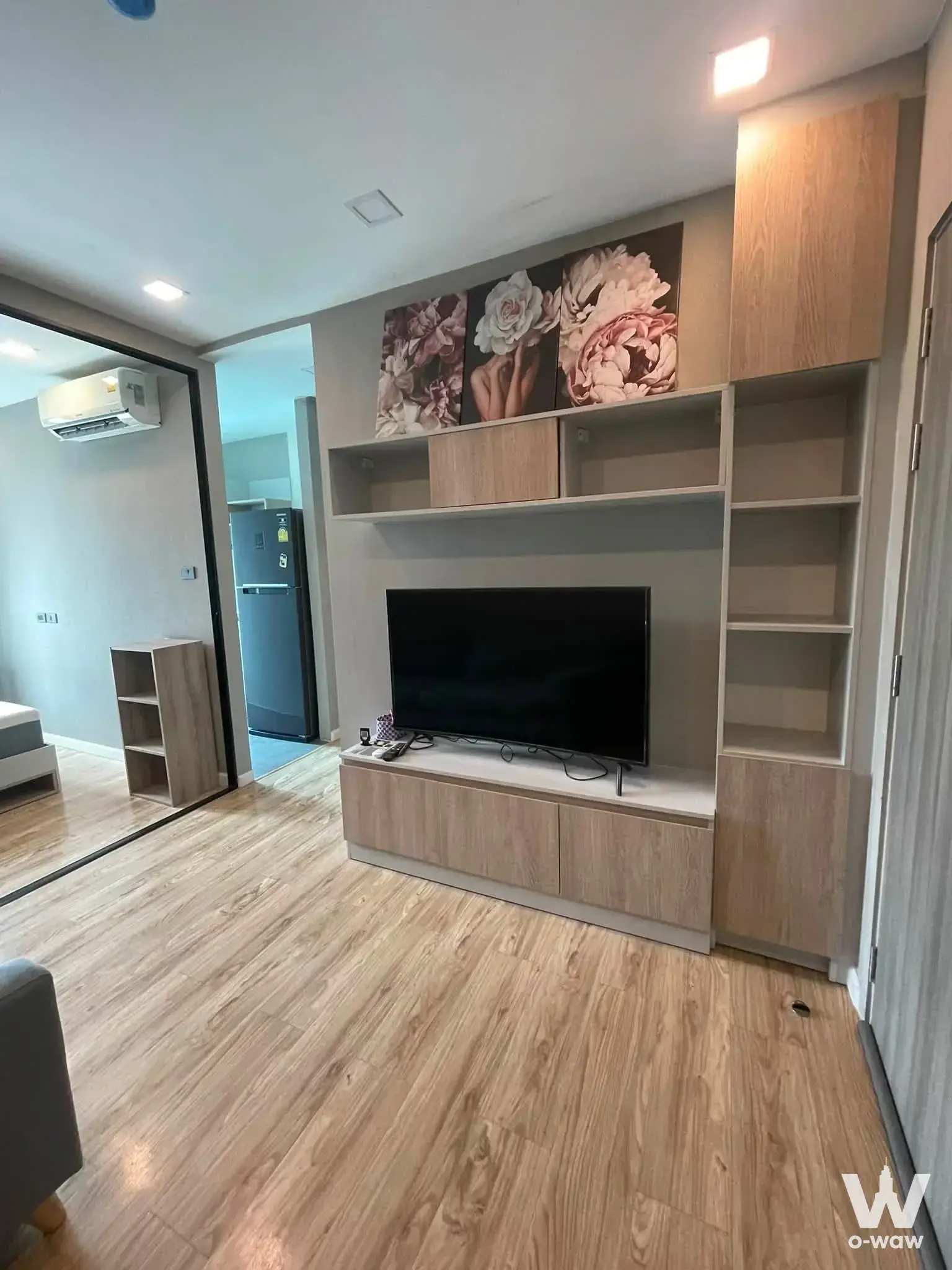 Groove Ratchada-Ladprao living room with oak flooring, media unit, and grey fabric sofa