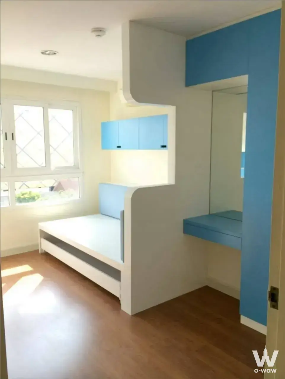 Compact bedroom in Lumpini Suite Ratchada-Rama 3 featuring blue joinery and built-in bed