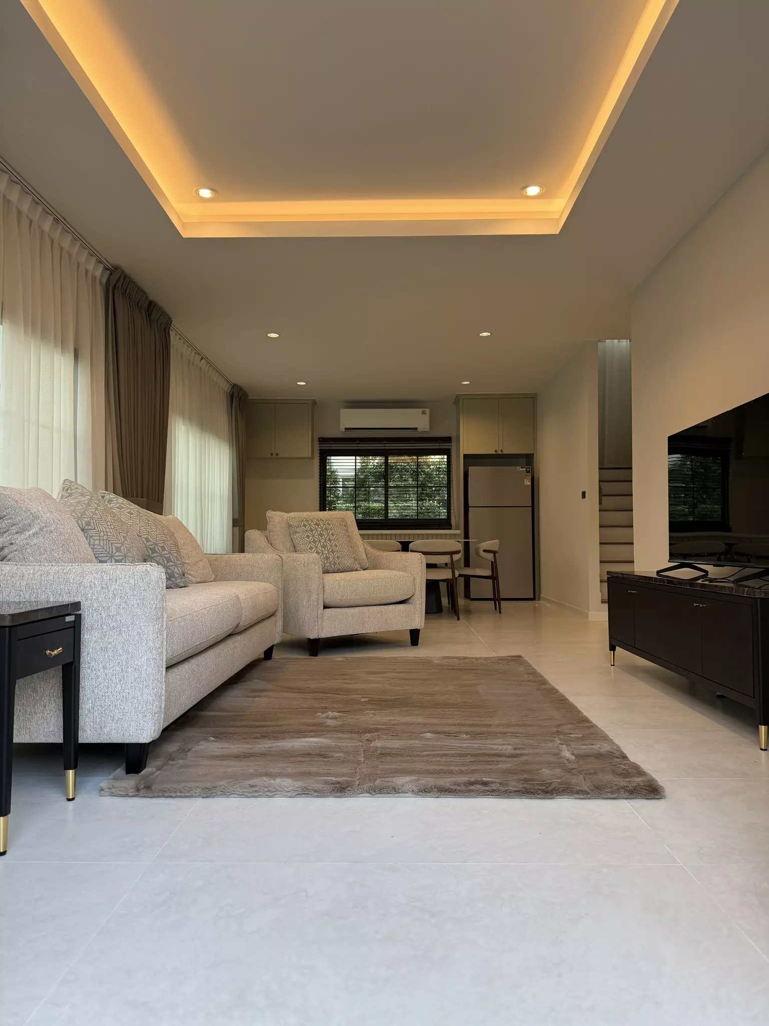 4-bed house for sale in Setthasiri Bangna KM.10 with open-plan living, beige sofa, and marble-look tile floors