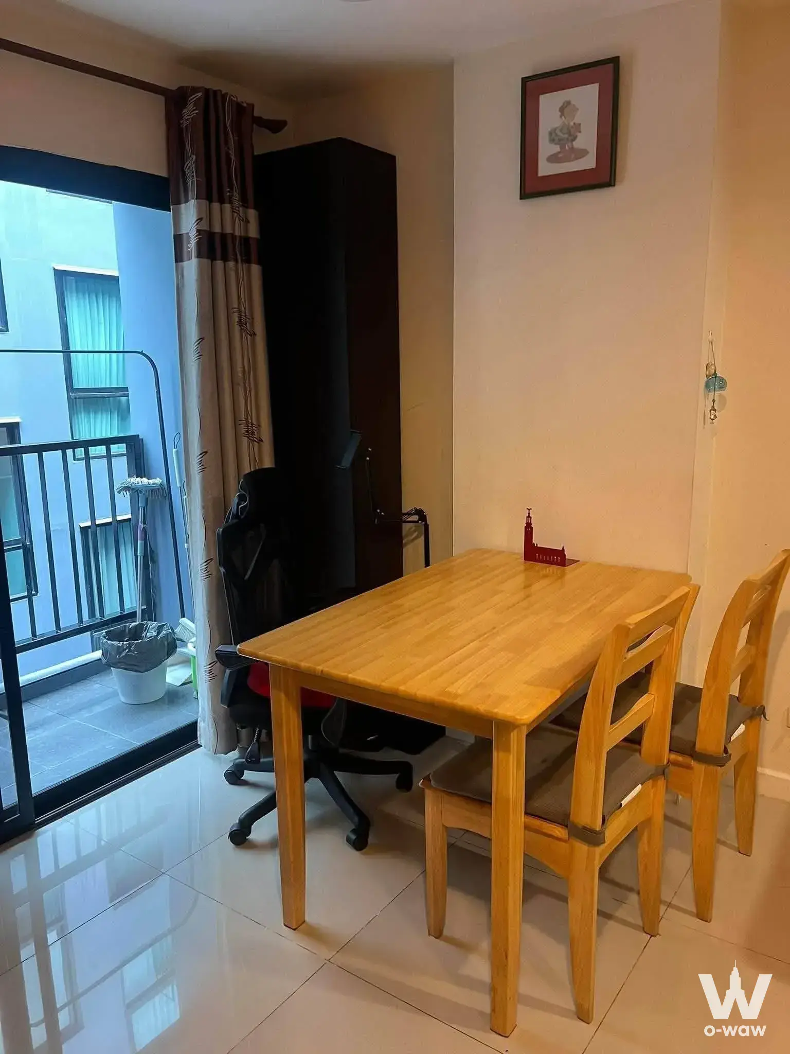Dining area with light oak table and chairs in a 1-bed condo for rent at Zenith Place Sukhumvit 71