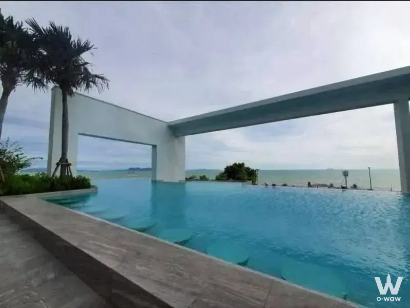 Rooftop infinity pool at AERAS Beachfront Jomtien offering turquoise water and distant sea views