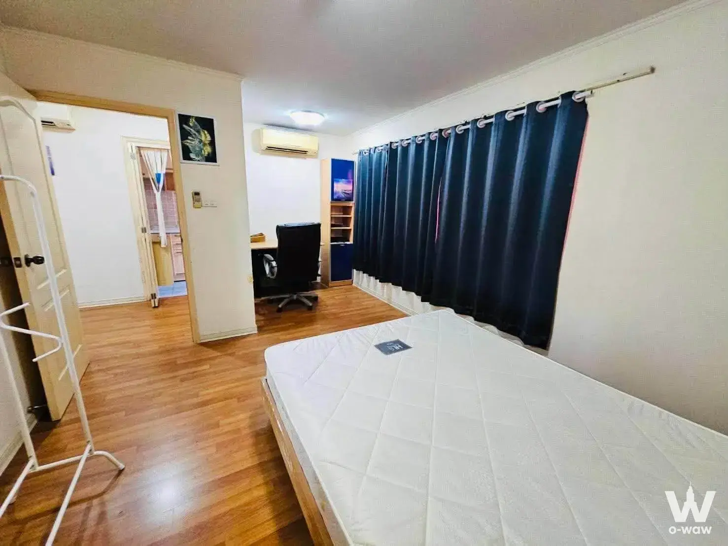 Spacious bedroom in a Lumpini Place Narathiwas rental with navy curtains and an open view into the tiled bathroom