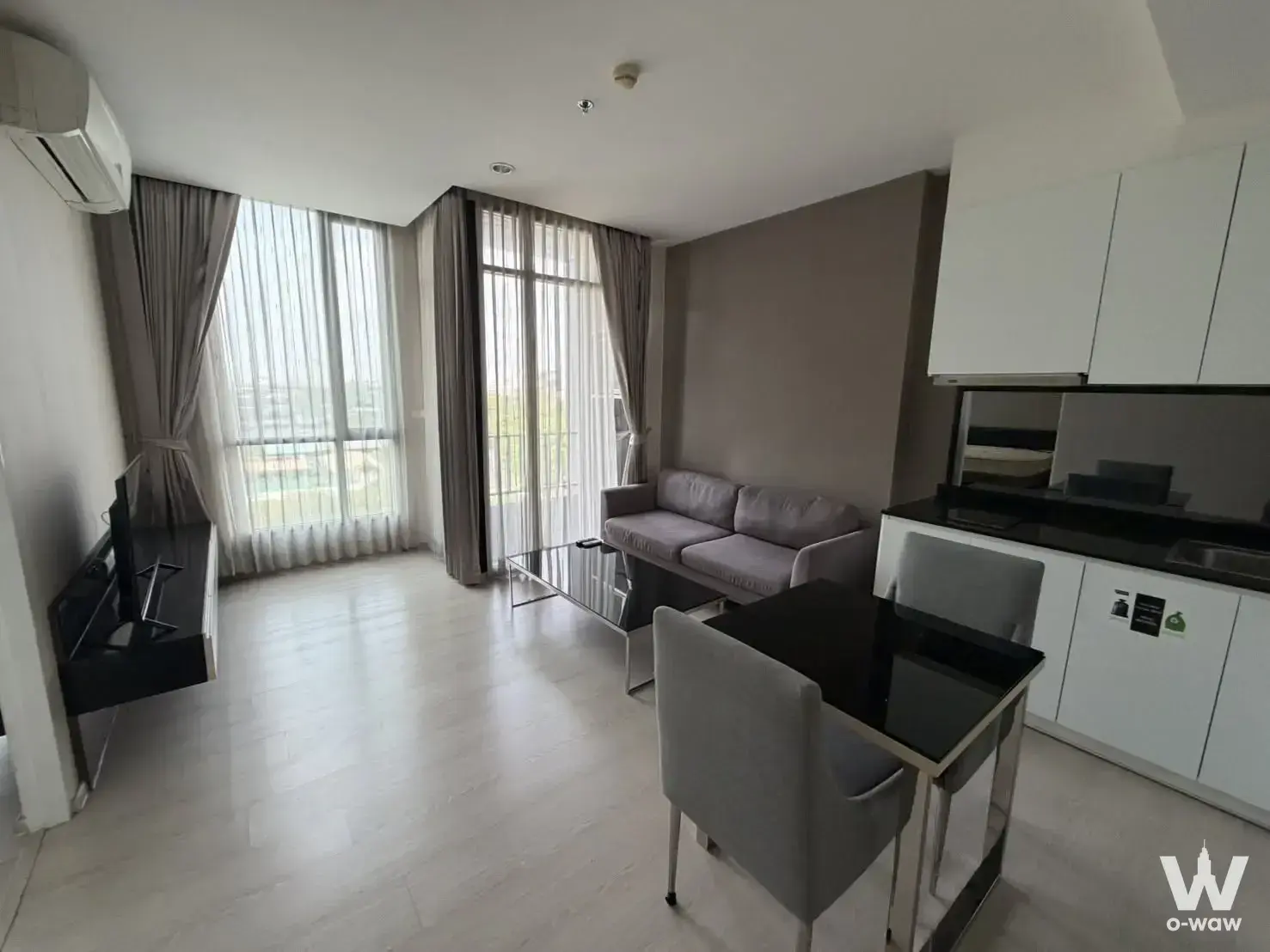 Open-plan living area with glass dining table in this 1-bed ESTELLA EKKAMAI condo for sale
