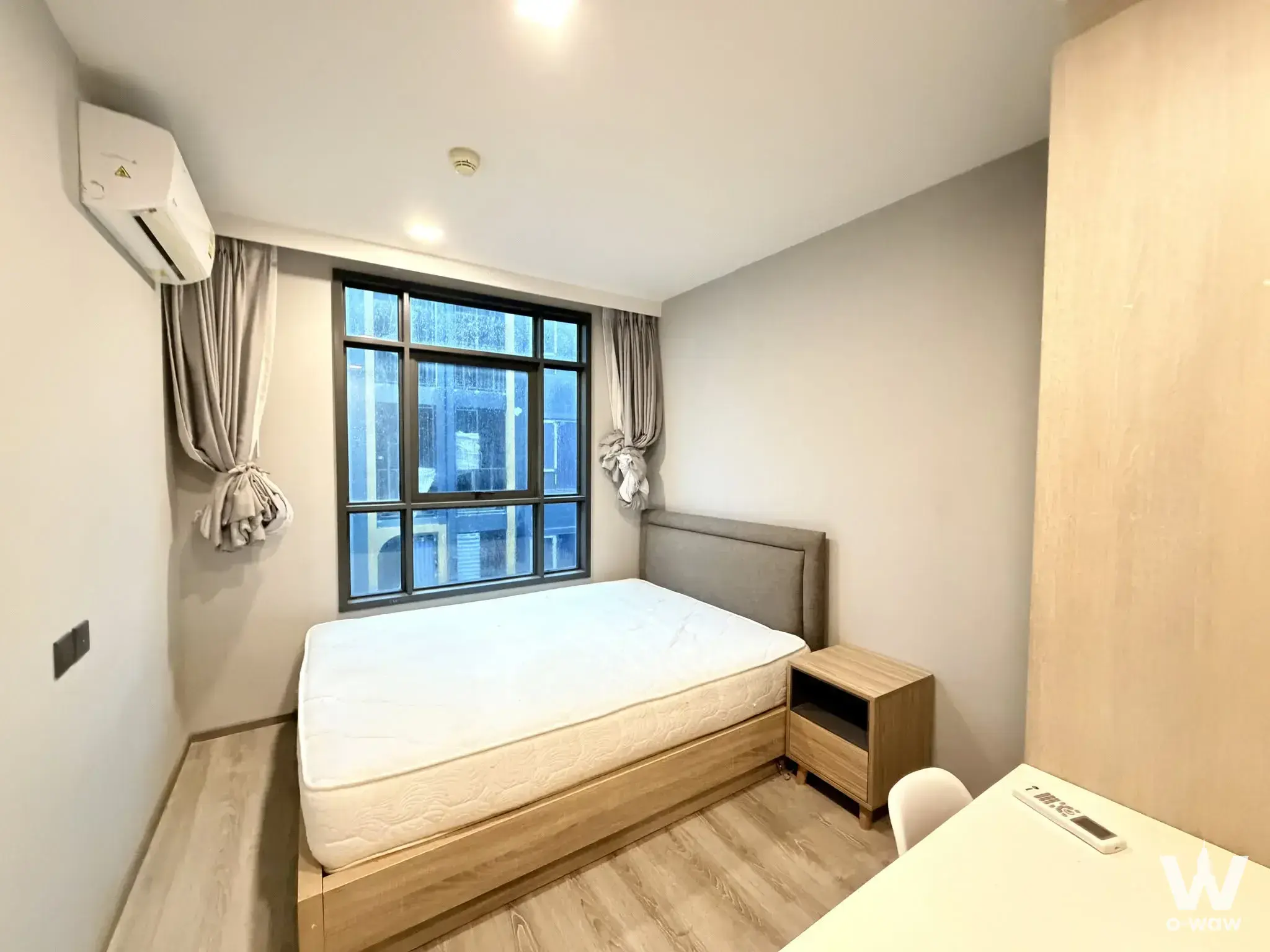 Modern 1-bed bedroom in Maestro 19 Ratchada with grey accent wall and large window