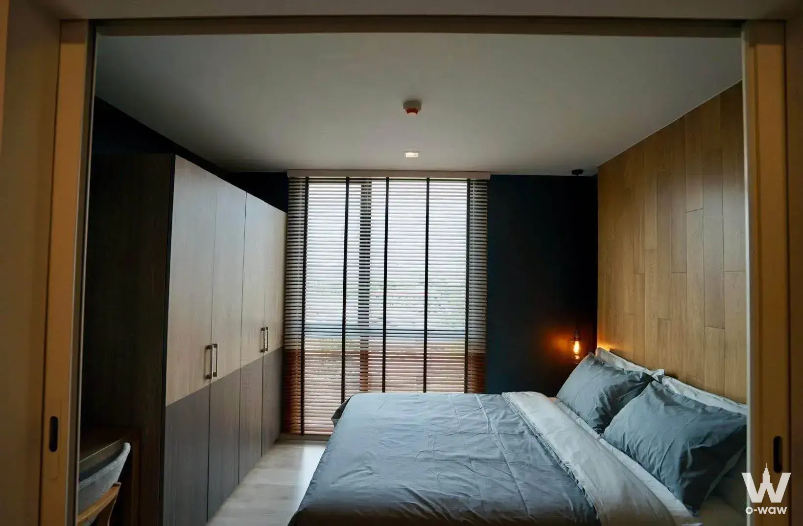 Furnished 1-bed condo bedroom in CHAMBERS CHAAN Ladprao-Wanghin featuring wood-paneled accent wall