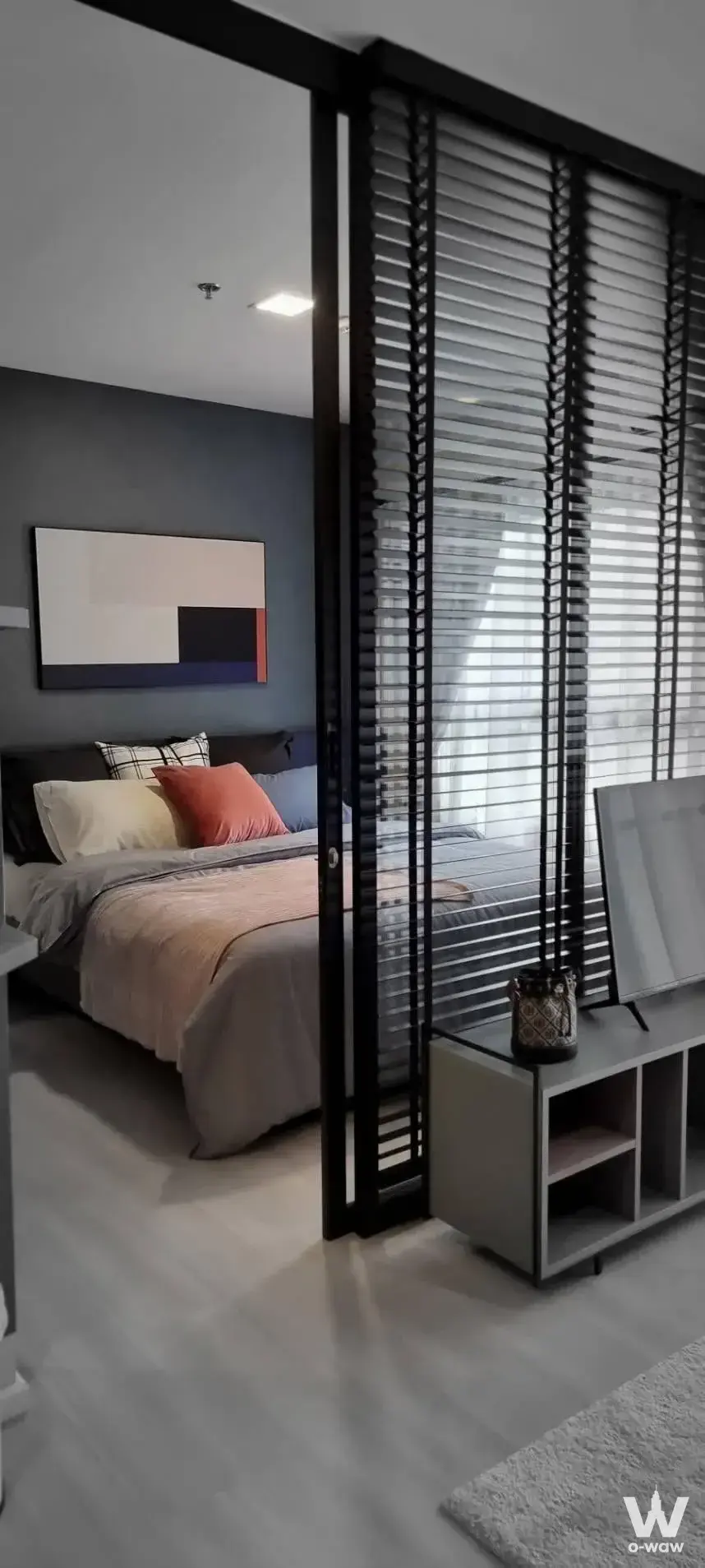 Bedroom in The Key MRT Phetkasem 48 featuring charcoal wall, orange accents, and sliding partition