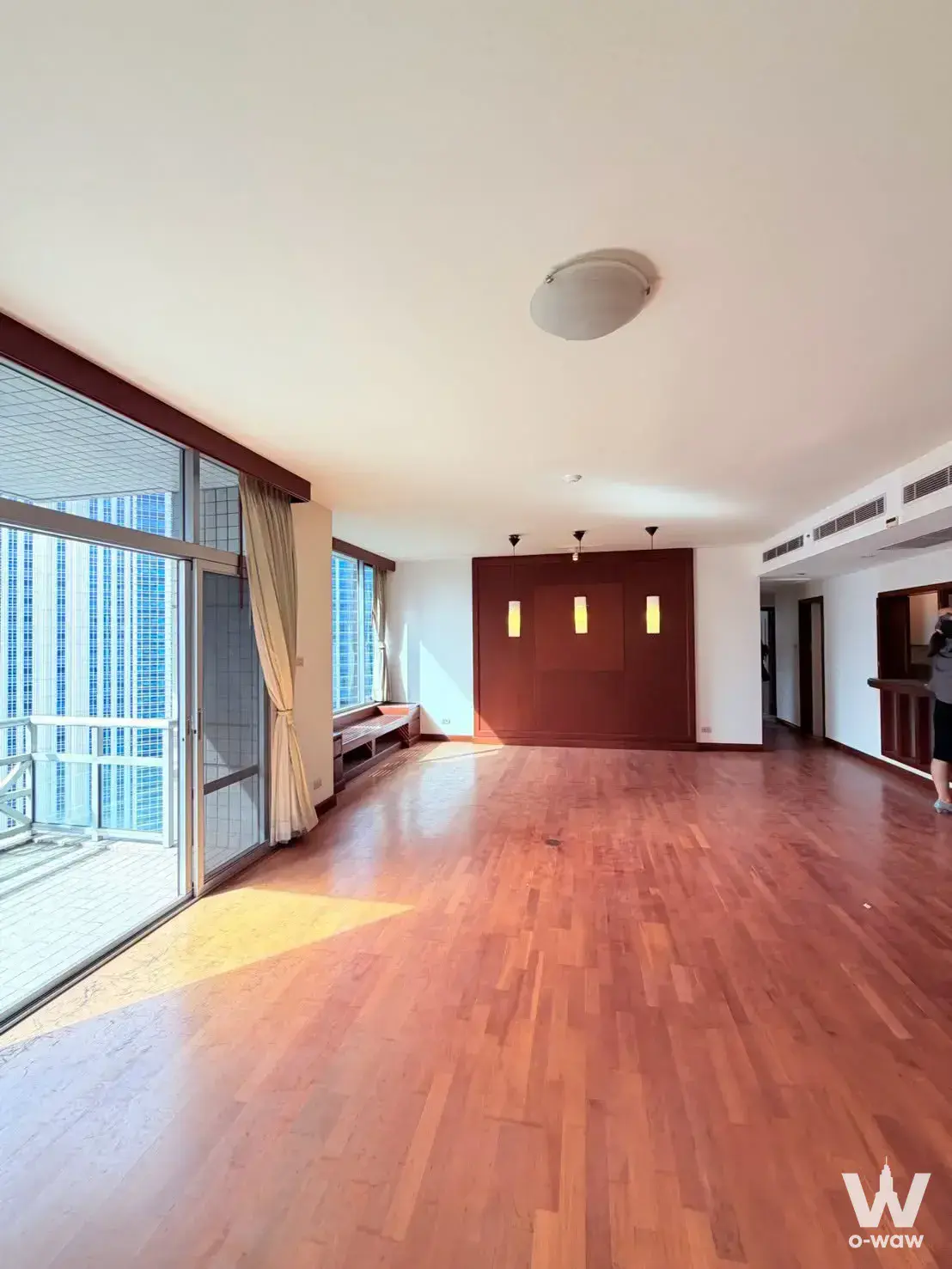 Empty living room in an All Seasons Mansion 3-bed condo with hardwood floors and sliding glass doors to the balcony