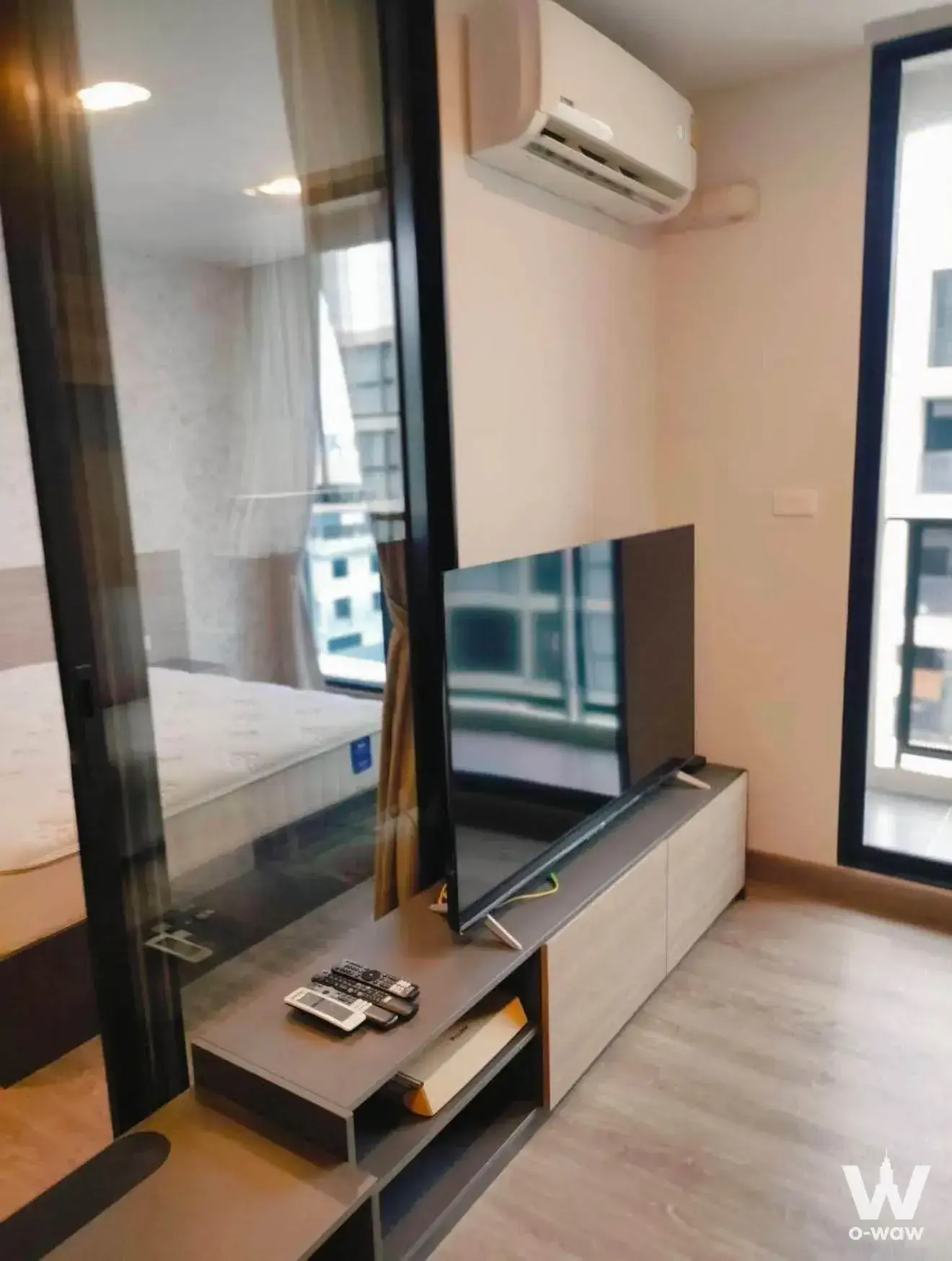 Living room with floating media console and glass partition in FLEXI Sathon condo