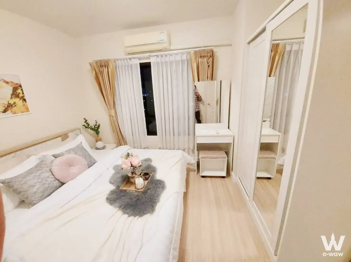 Queen bed with pink accents in a 2-bed condo for sale at 624 Condolette