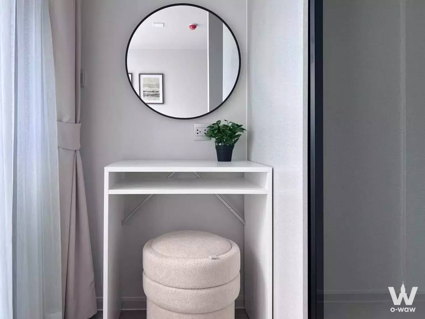 Entryway in Atmoz Oasis Onnut featuring a round mirror, white console, and frosted sliding door
