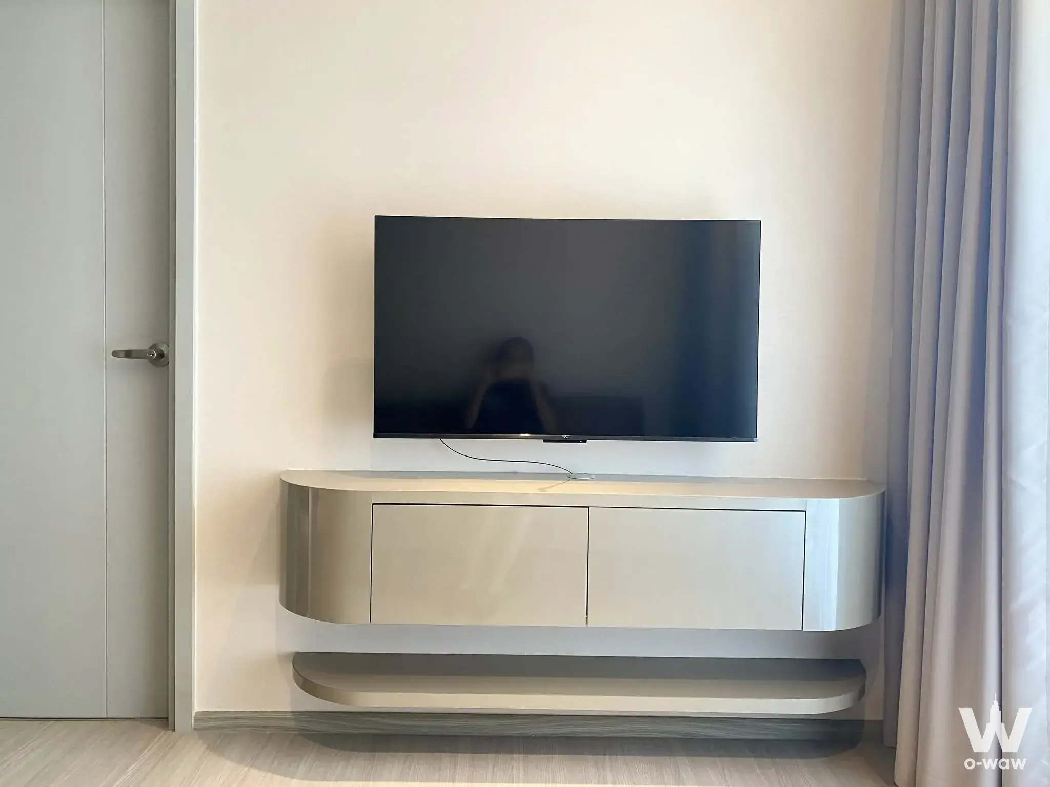 2-bed condo for rent in Aspire Sukhumvit-On Nut with minimalist living room, large TV, and silver floating console
