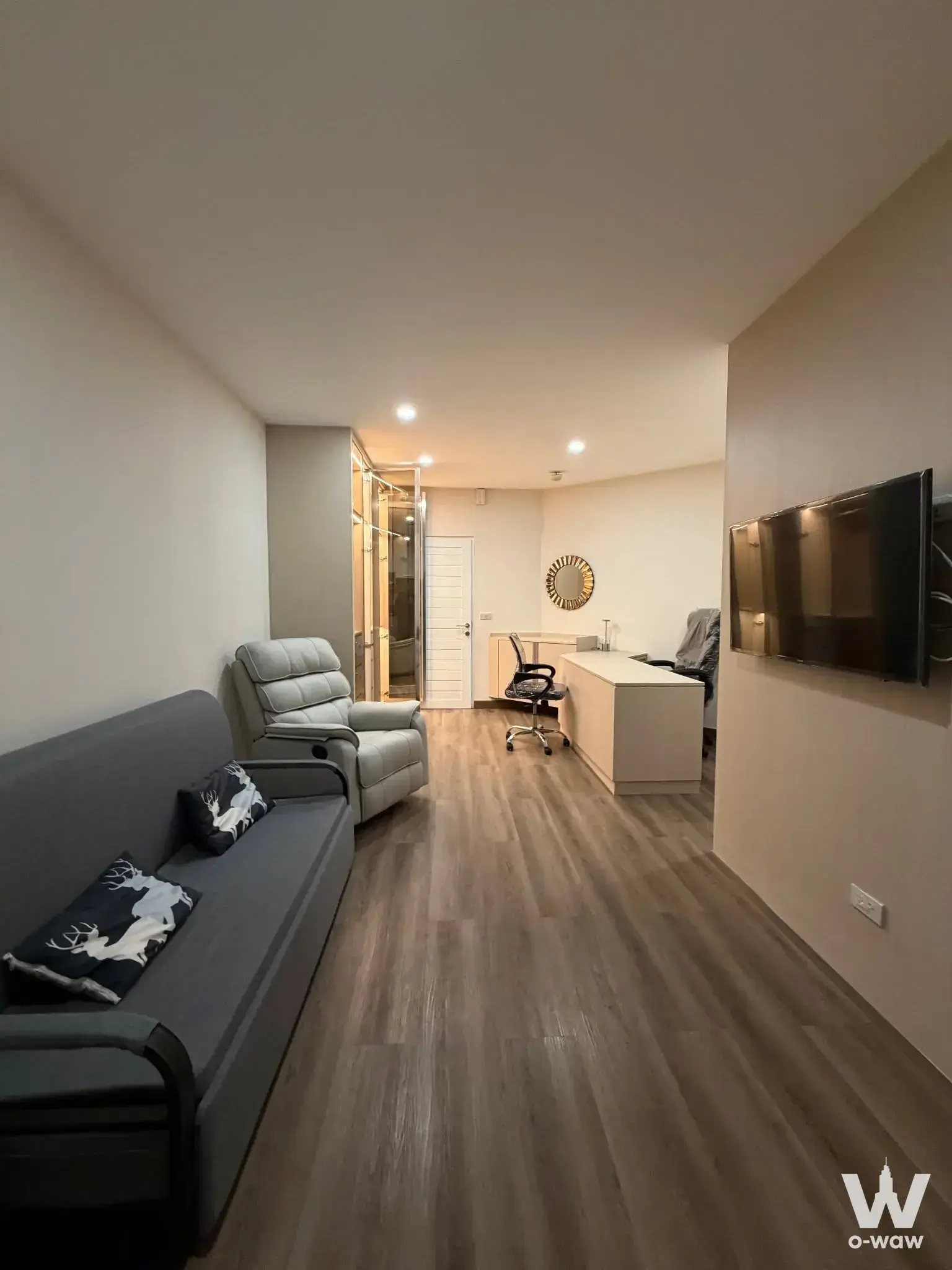 Living room with navy deer-print sofa and office area, 0-bed condo for sale in Monterey Place