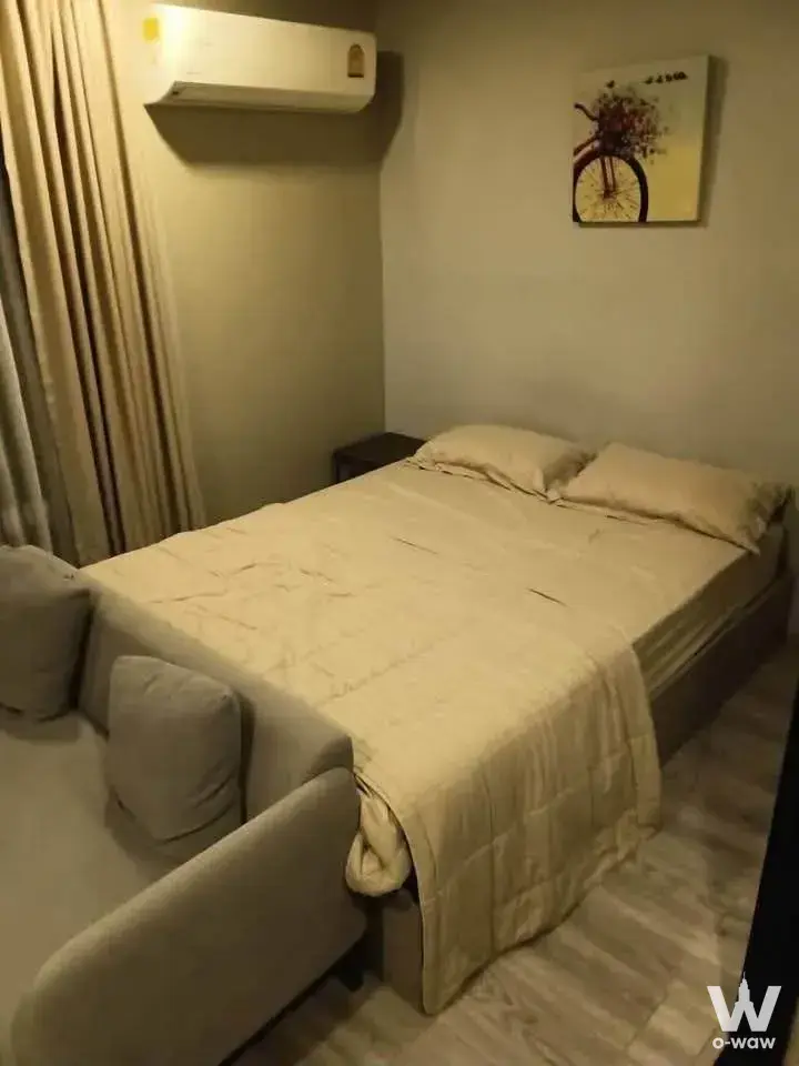 Cozy 1-bed condo in Maestro 14 Siam-Ratchathewi with a queen-size bed, bicycle motif art, and neutral tones creating a tidy,