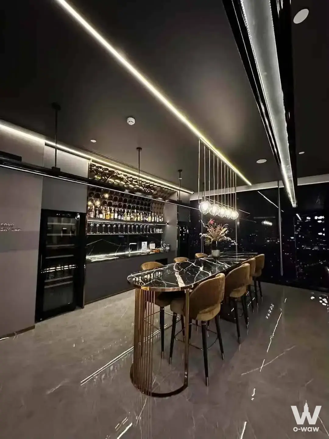 Luxury private bar lounge for sale in SOHO Bangkok Ratchada with black marble table, gold accents, and night skyline view